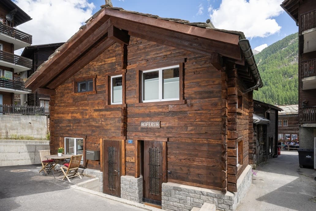 Log chalet exterior with private patio and stone foundations