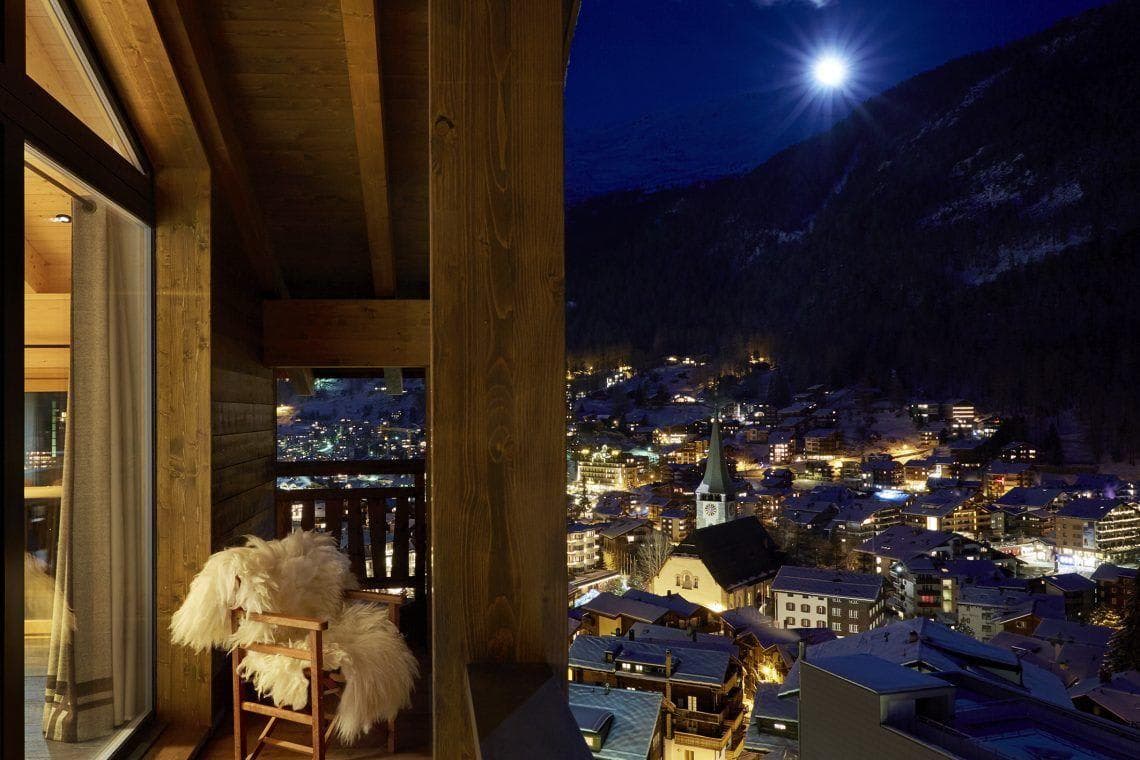 Private balcony with sheepskin seating and mountain village views