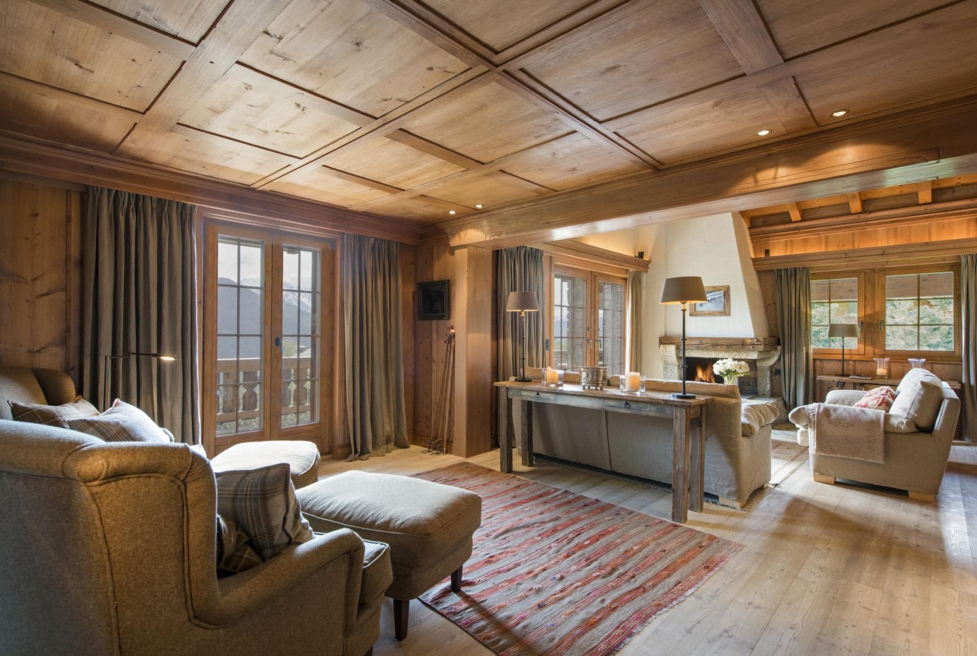 Living area with wood-paneled ceiling, wood-burning fireplace, and mountain views