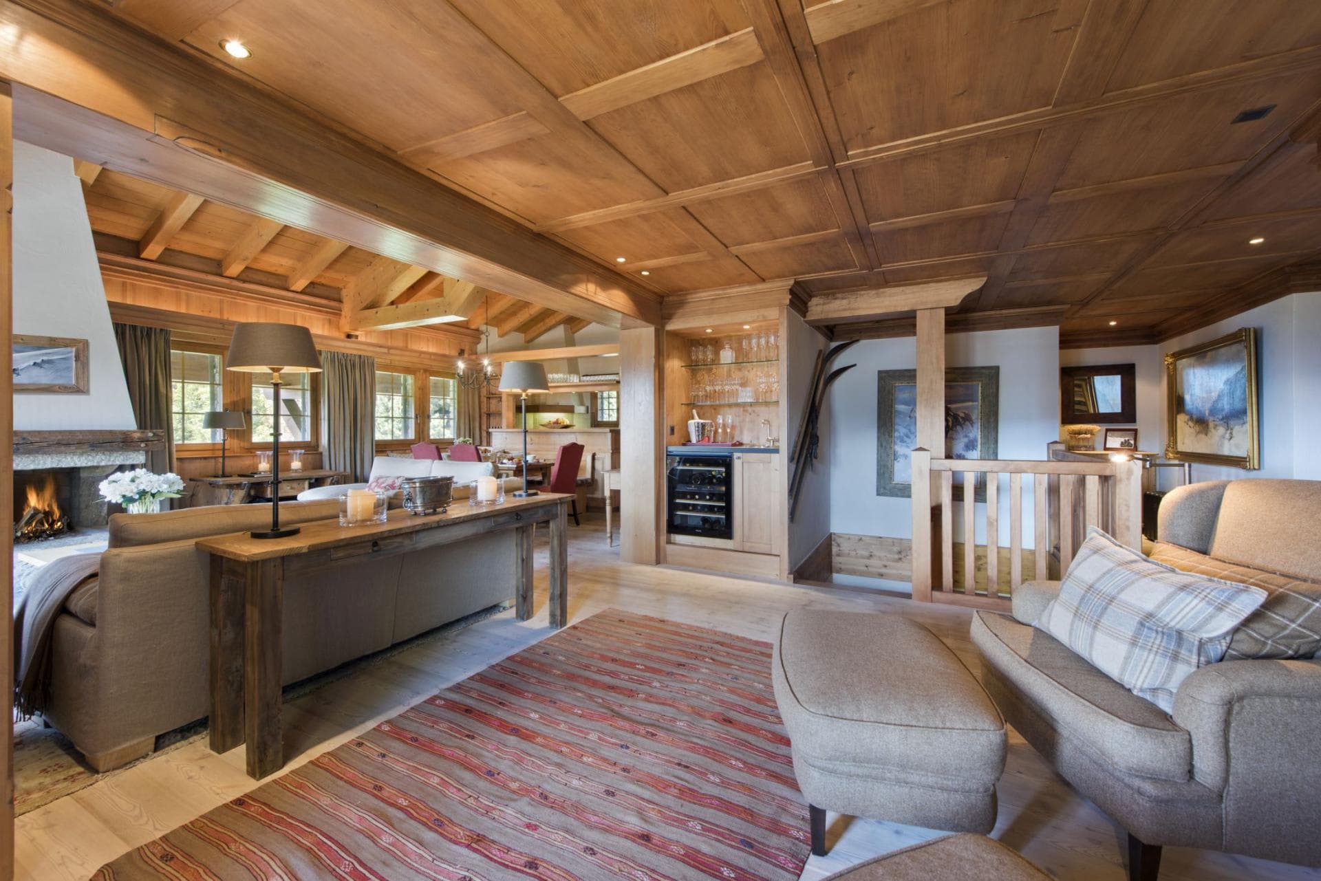 Open living area with wood-paneled ceilings, fireplace, and integrated wine fridge