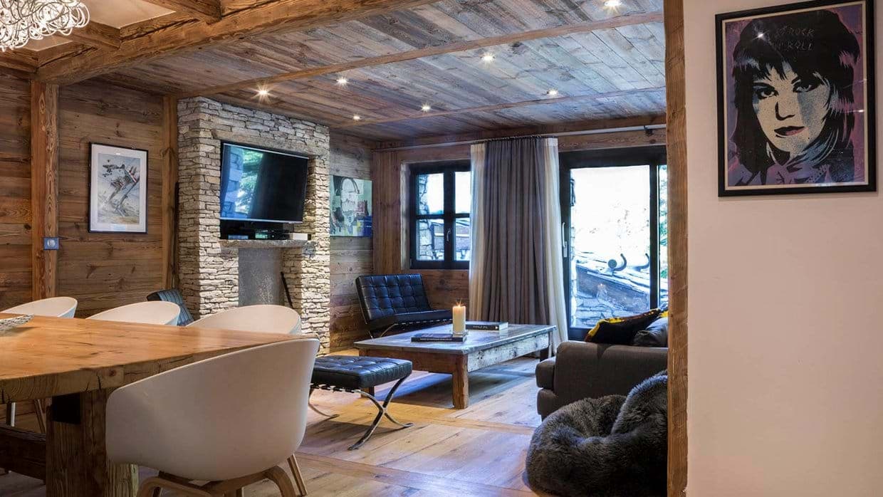 Open-plan living area with reclaimed wood walls and stone fireplace