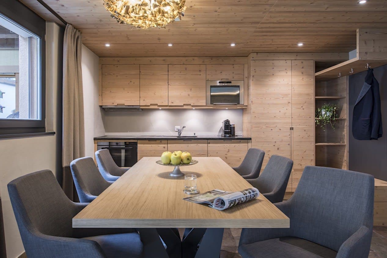 Dining area for 6 with wood-paneled kitchenette and espresso machine