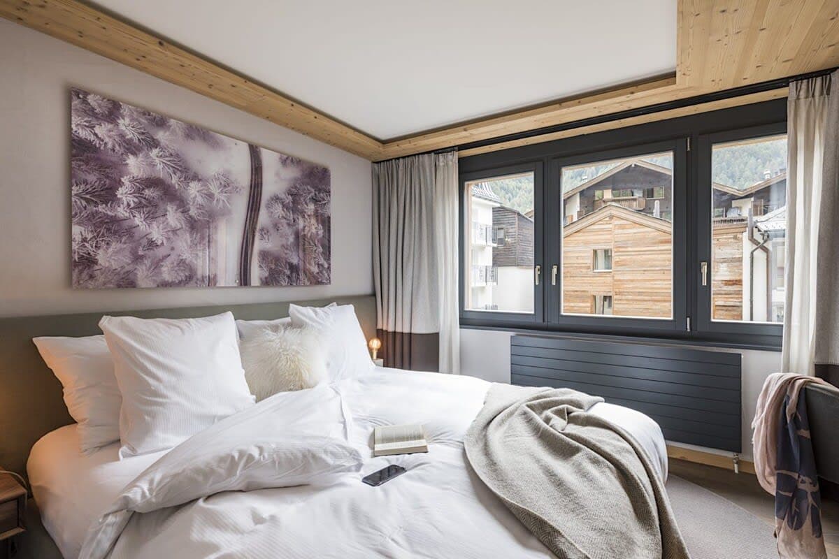 Guest bedroom with king bed and village views