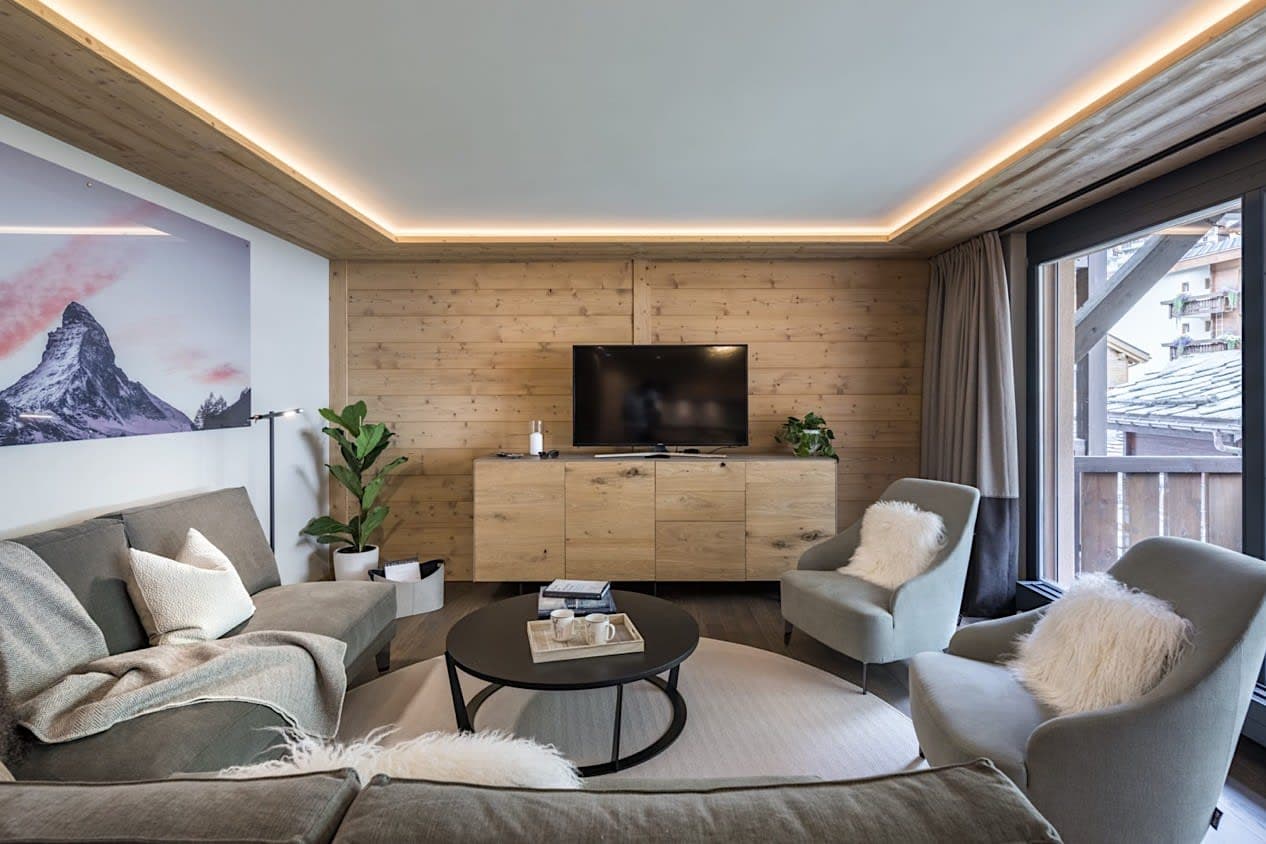 Living area with smart TV, wood paneling, and balcony access