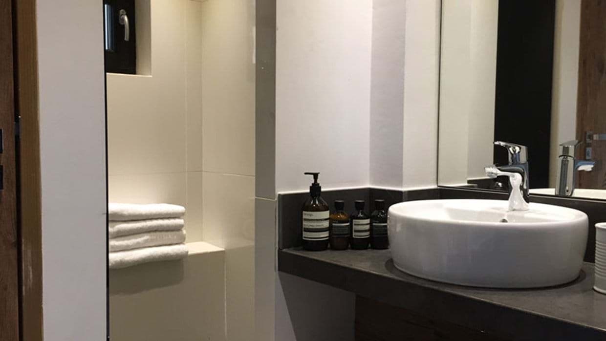 Bathroom vanity with vessel sink and Aesop toiletries provided