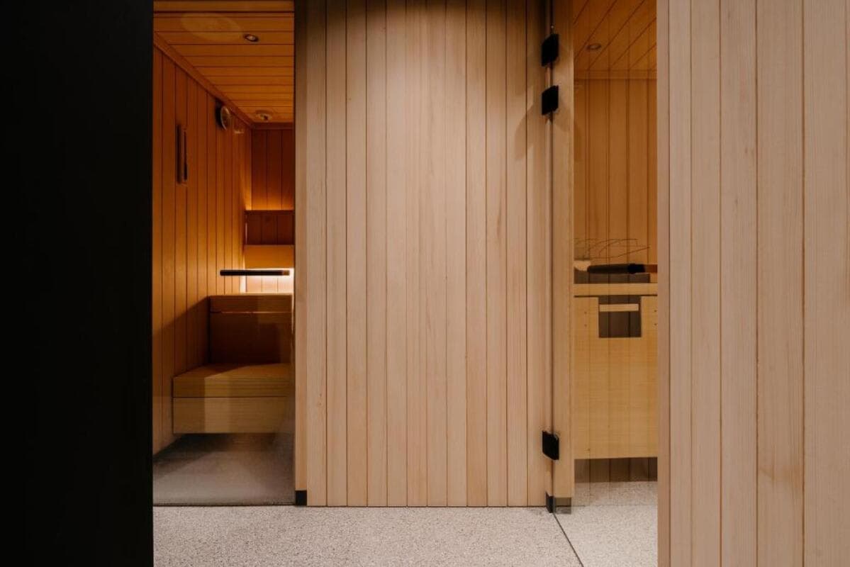 Private sauna with tiered wood seating and glass door