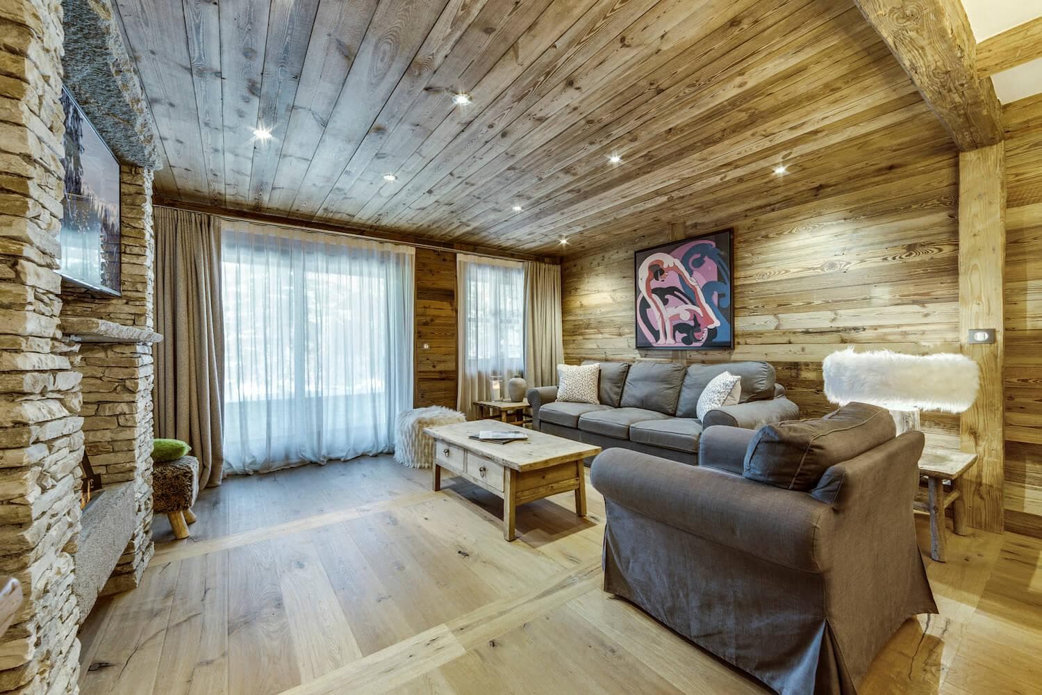 Living area with stone fireplace and reclaimed wood walls and ceiling