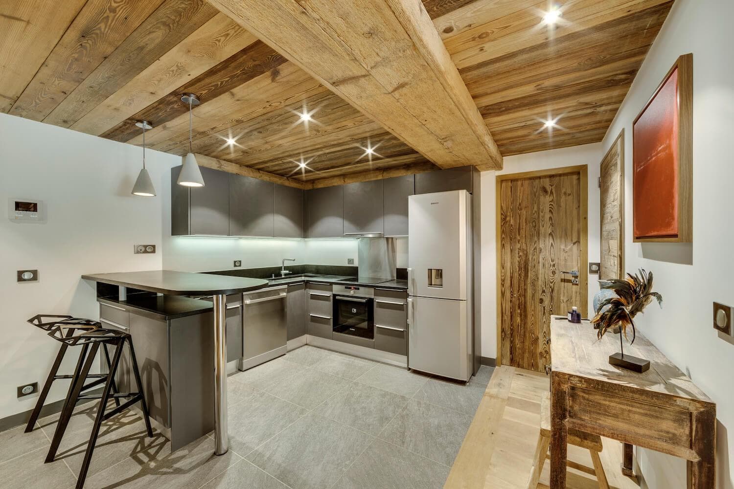 Kitchen with reclaimed wood ceilings, breakfast bar, and integrated dishwasher