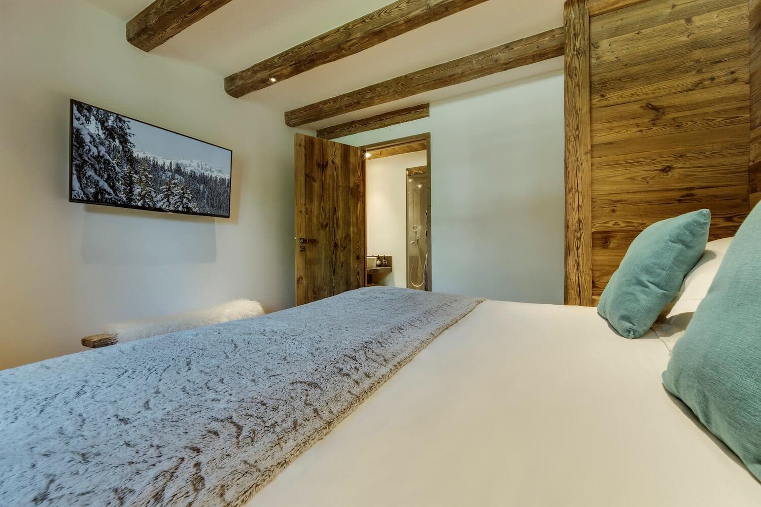 Bedroom with wall-mounted TV and ensuite bathroom with walk-in shower