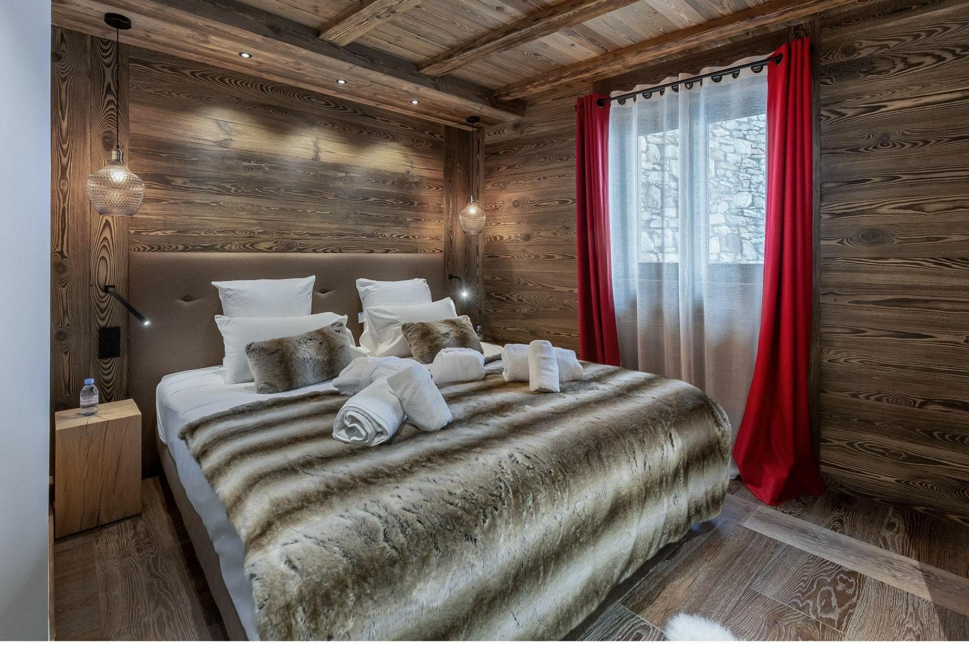 Wood-paneled bedroom with king bed and reading lights