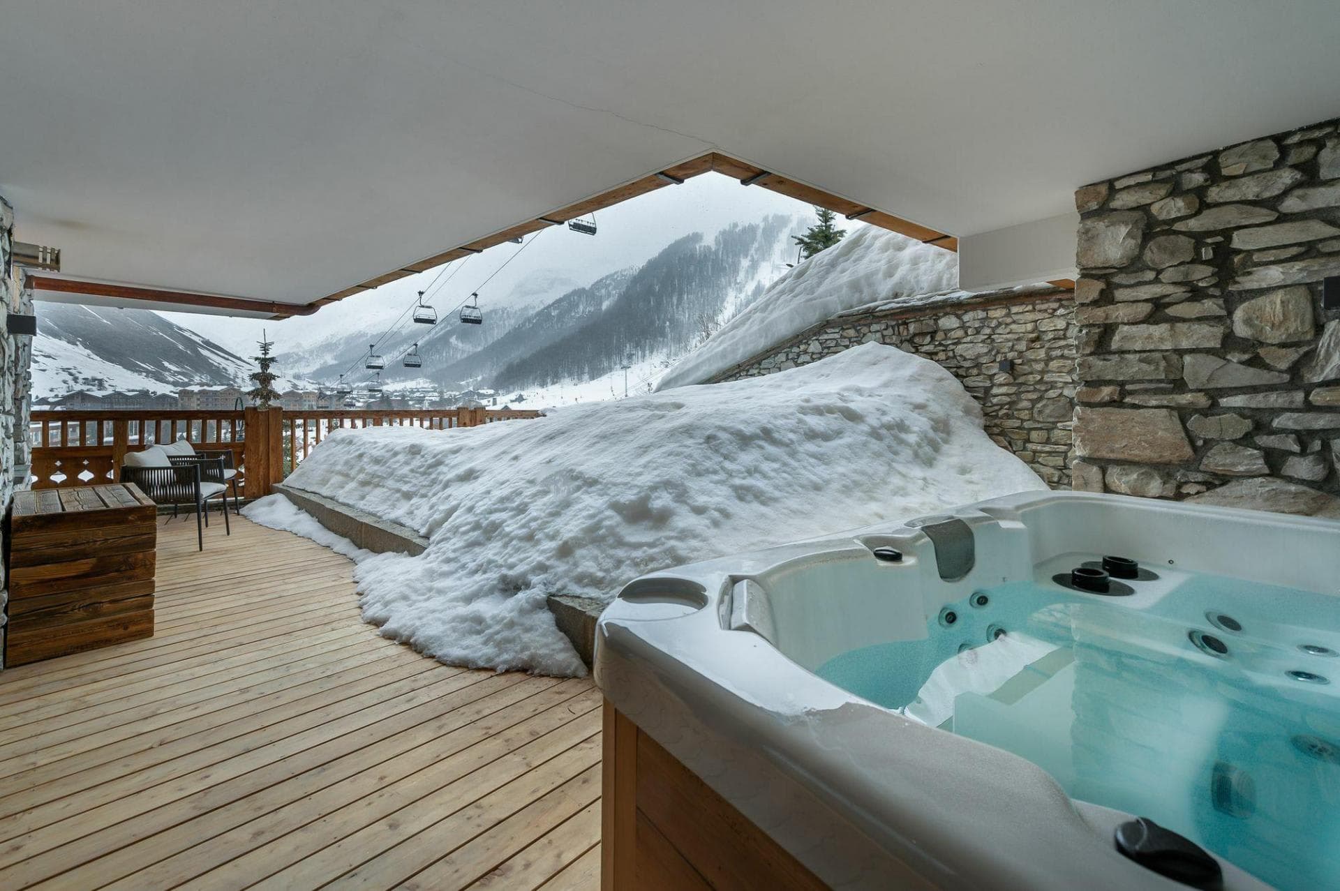 Covered outdoor hot tub with mountain views and ski lift access
