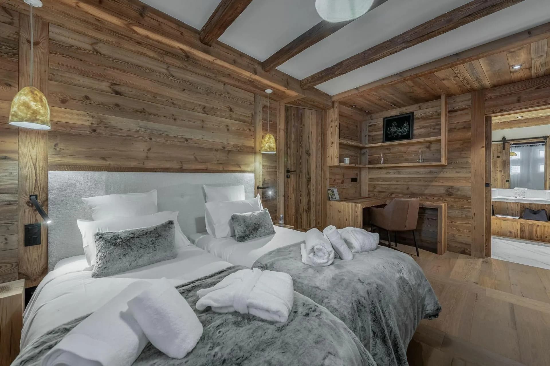 Guest bedroom with two twin beds, workspace, and en suite bathroom