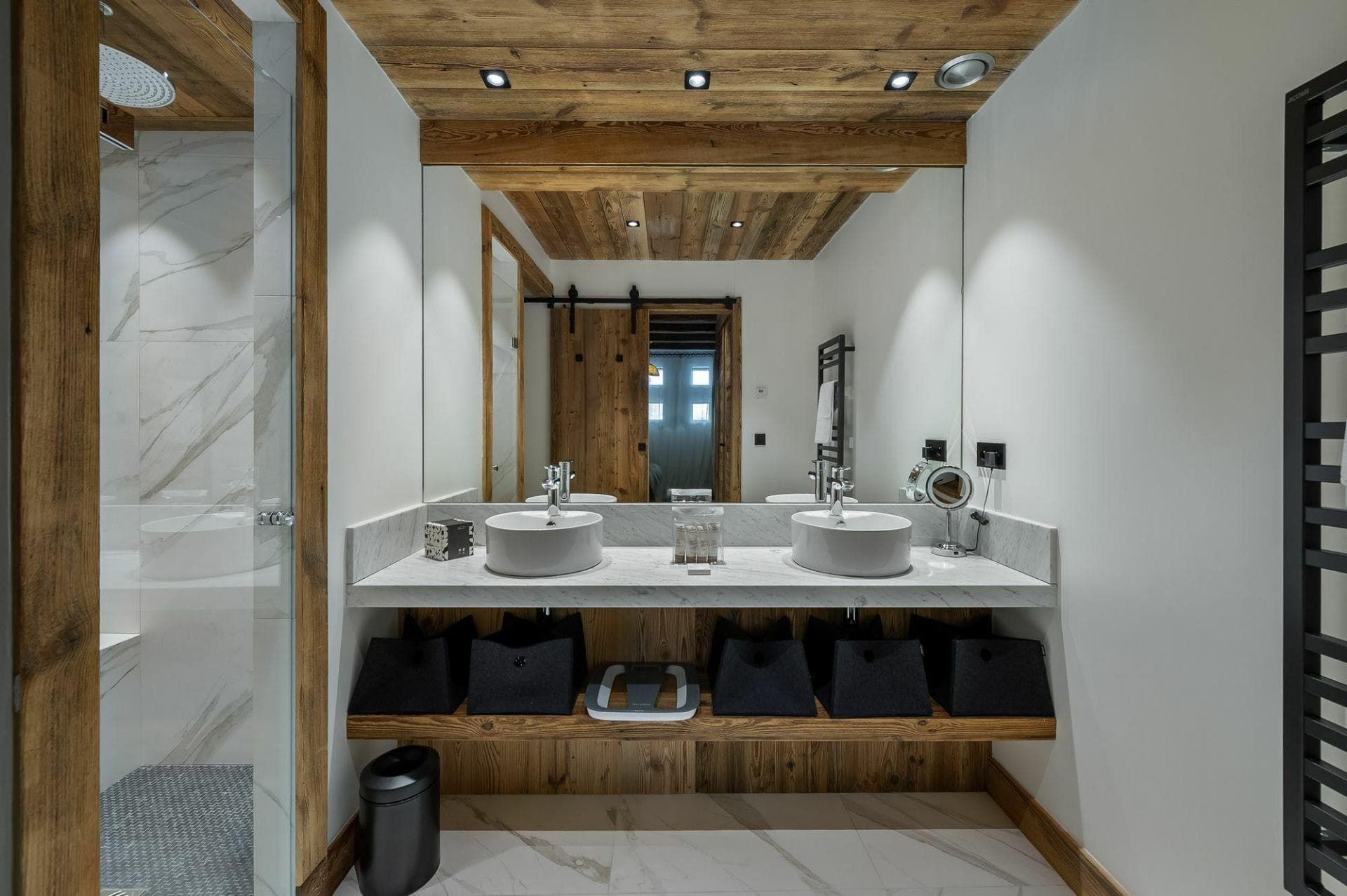 Bathroom with dual vessel sinks, rainfall shower, and heated towel rack