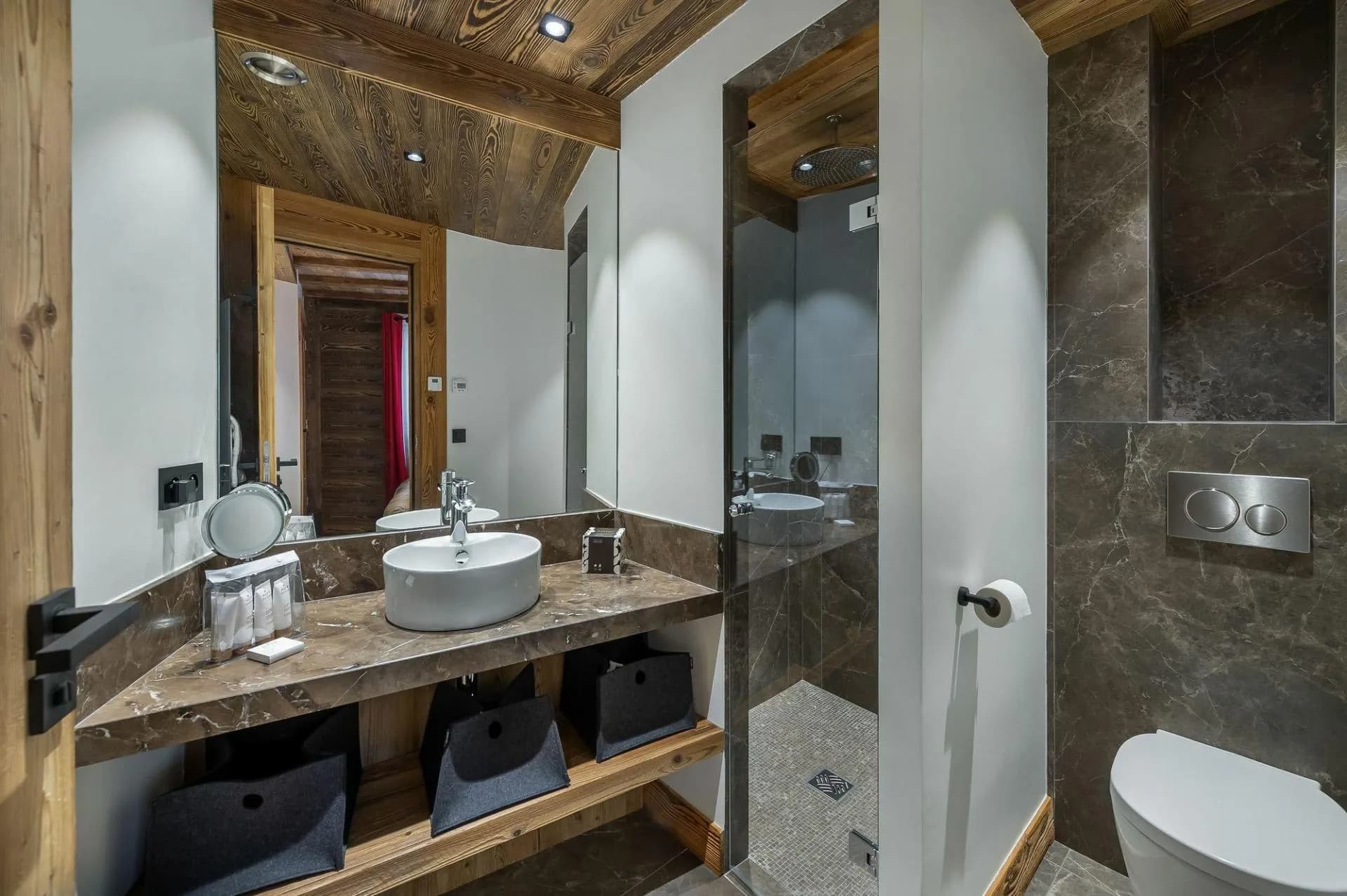 Bathroom with rainfall shower head and marble-style stone tiles