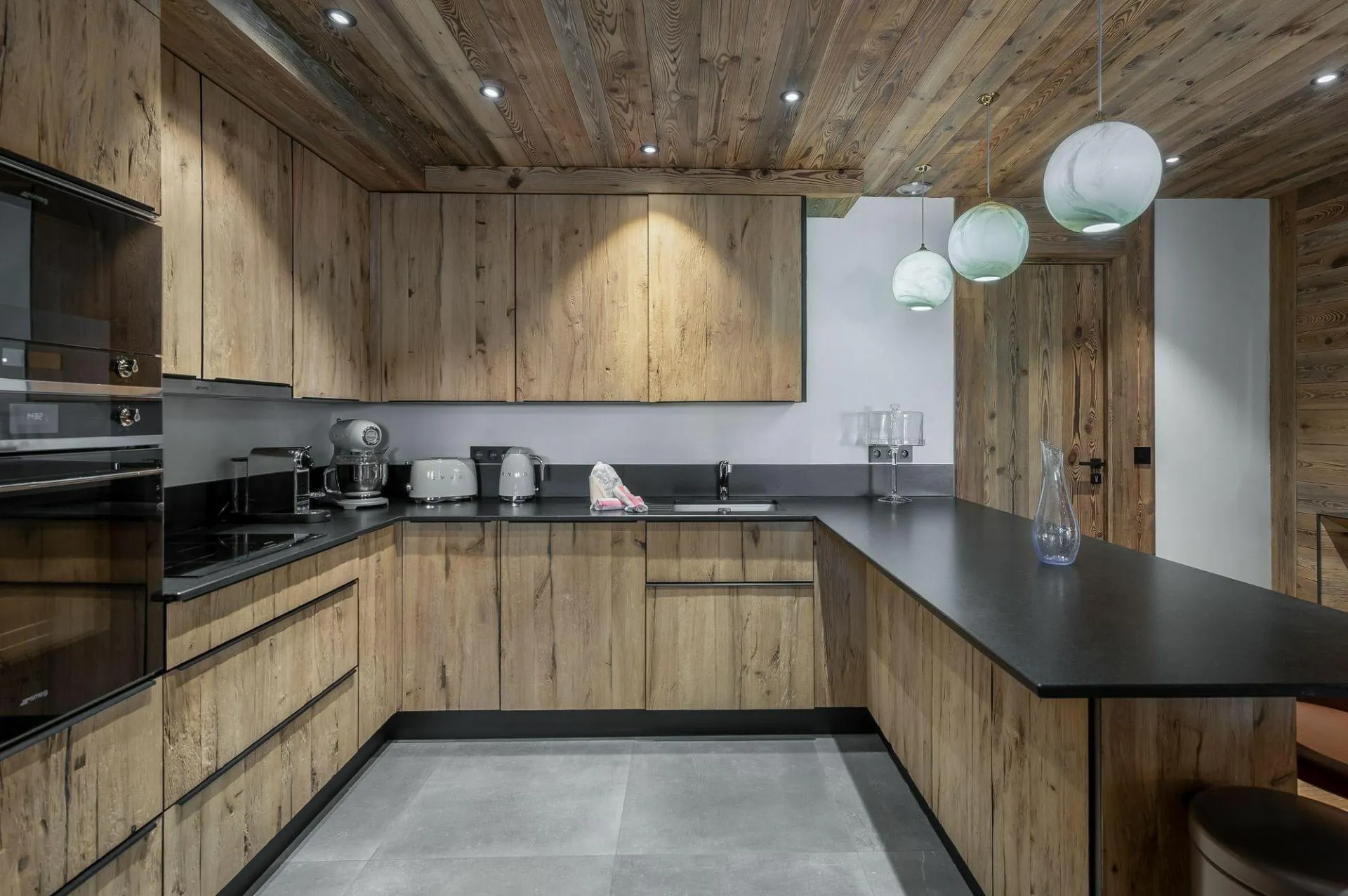 U-shaped kitchen with Smeg appliances and breakfast bar seating