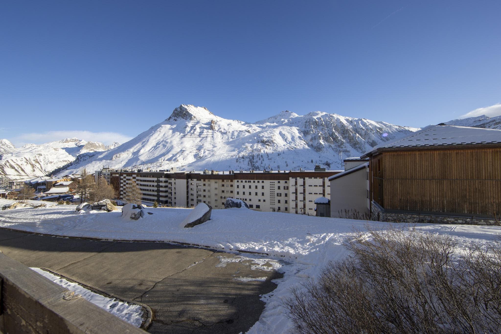 Balcony view of snow-capped mountains and neighbouring ski resort buildings