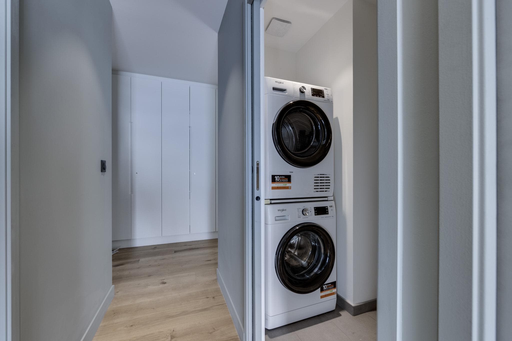 Stacked Whirlpool washer and dryer behind sliding pocket door