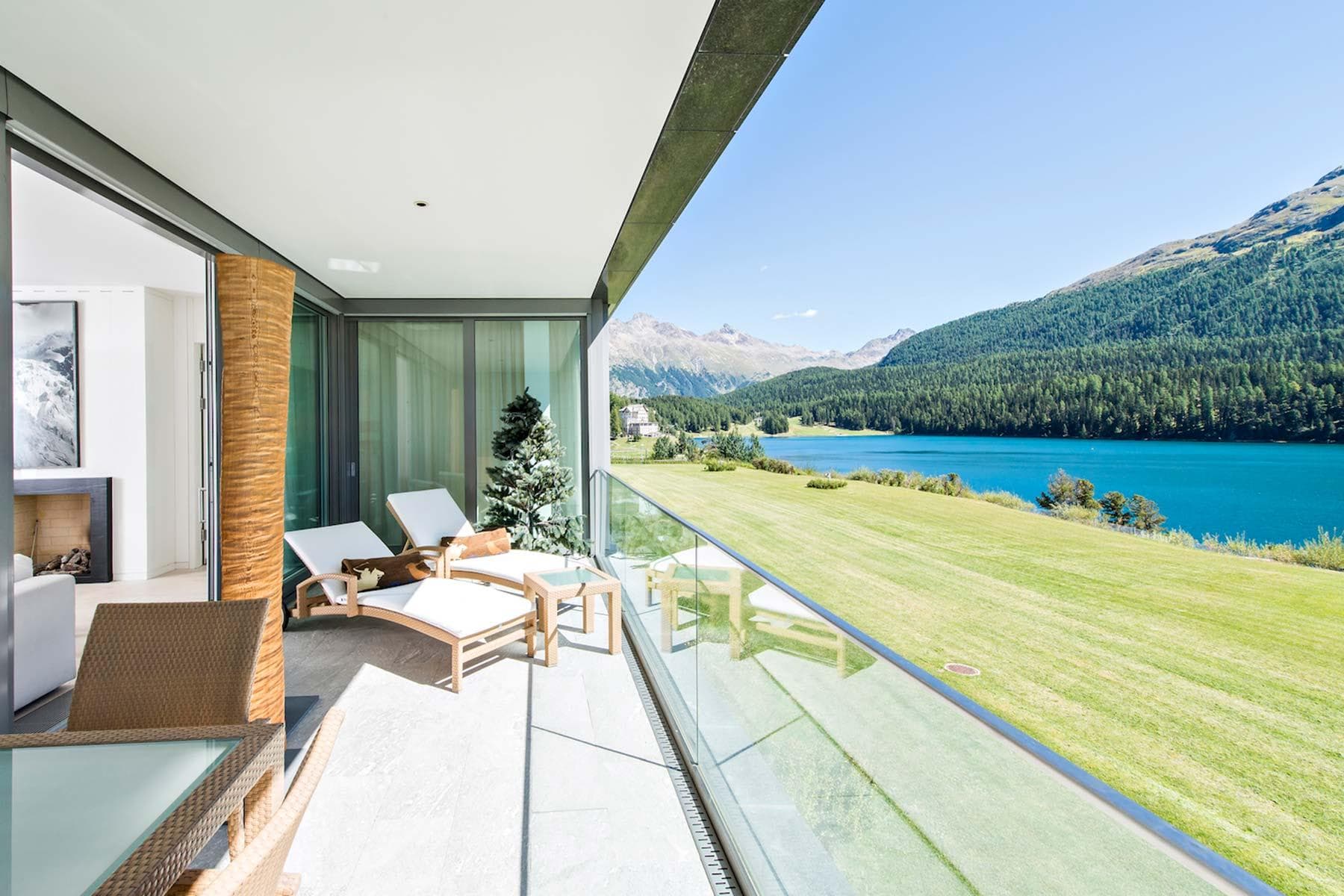 Covered terrace with sun loungers and glass railing for lake views