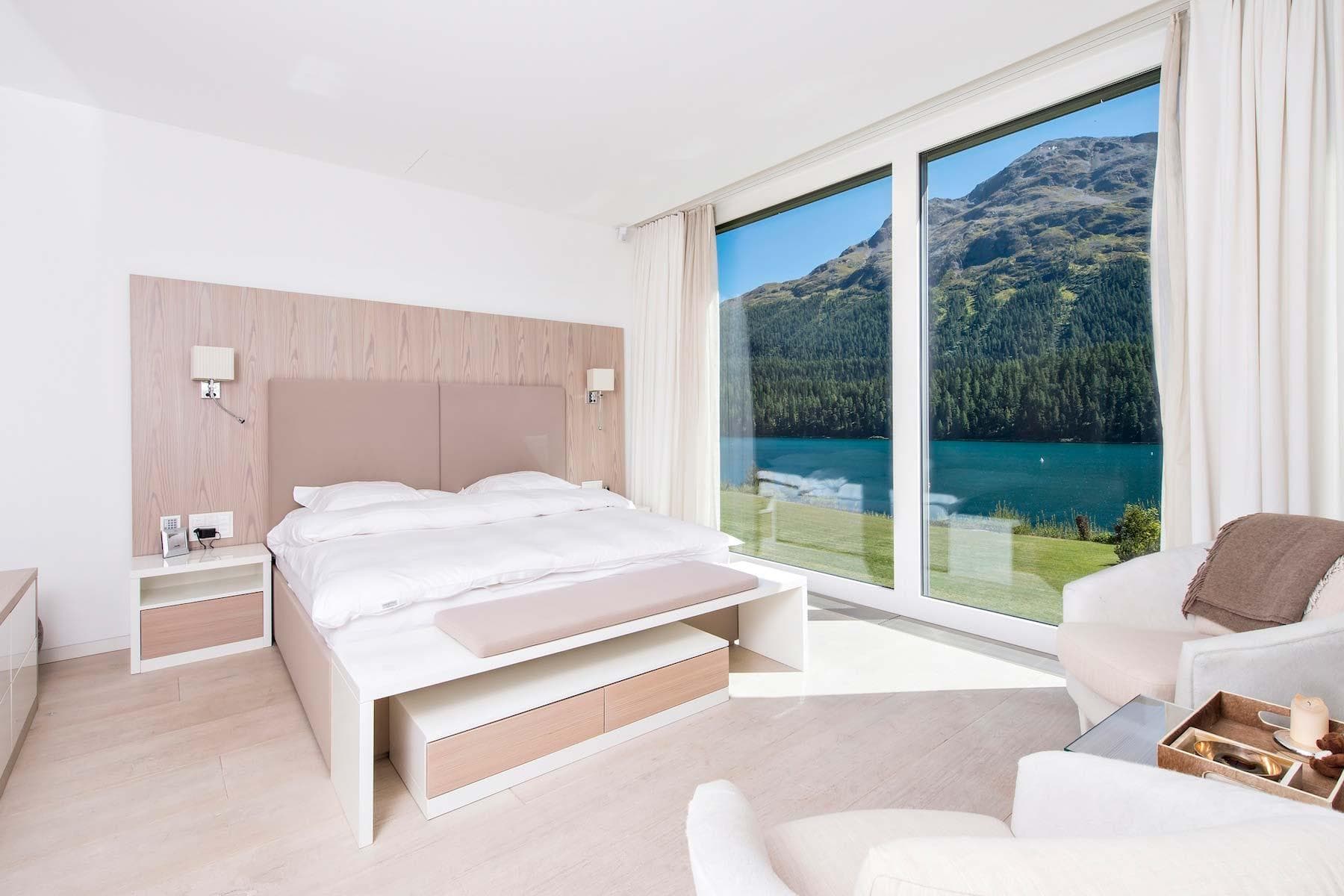 Primary bedroom with king bed and floor-to-ceiling lake views