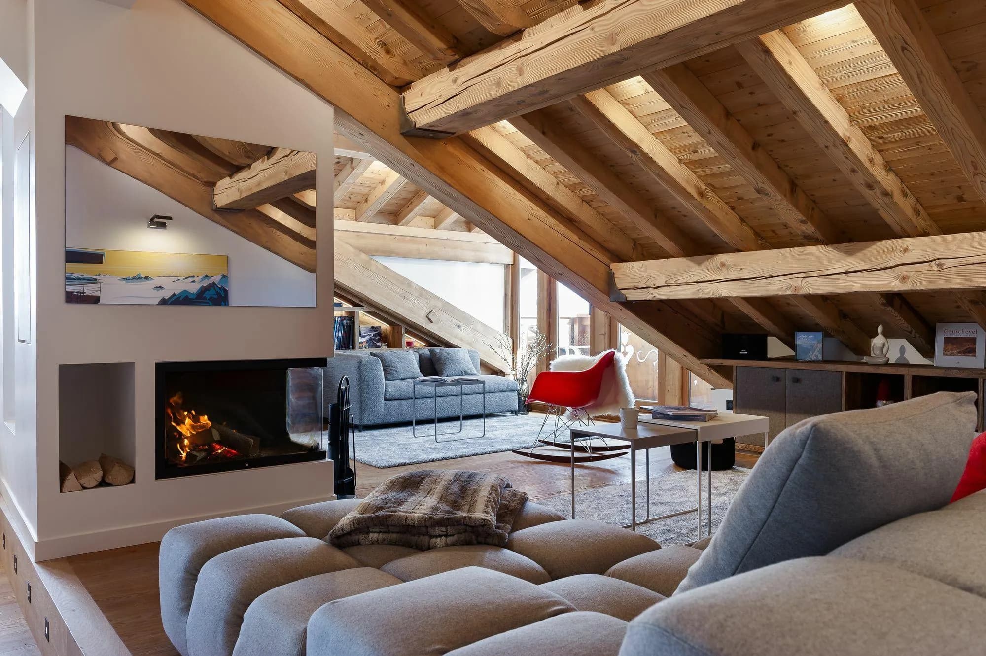 Loft living area with wood-burning fireplace and exposed timber beams