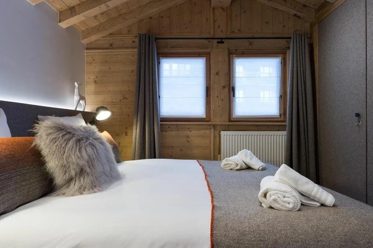 Guest bedroom with wood-paneled walls and built-in closet storage