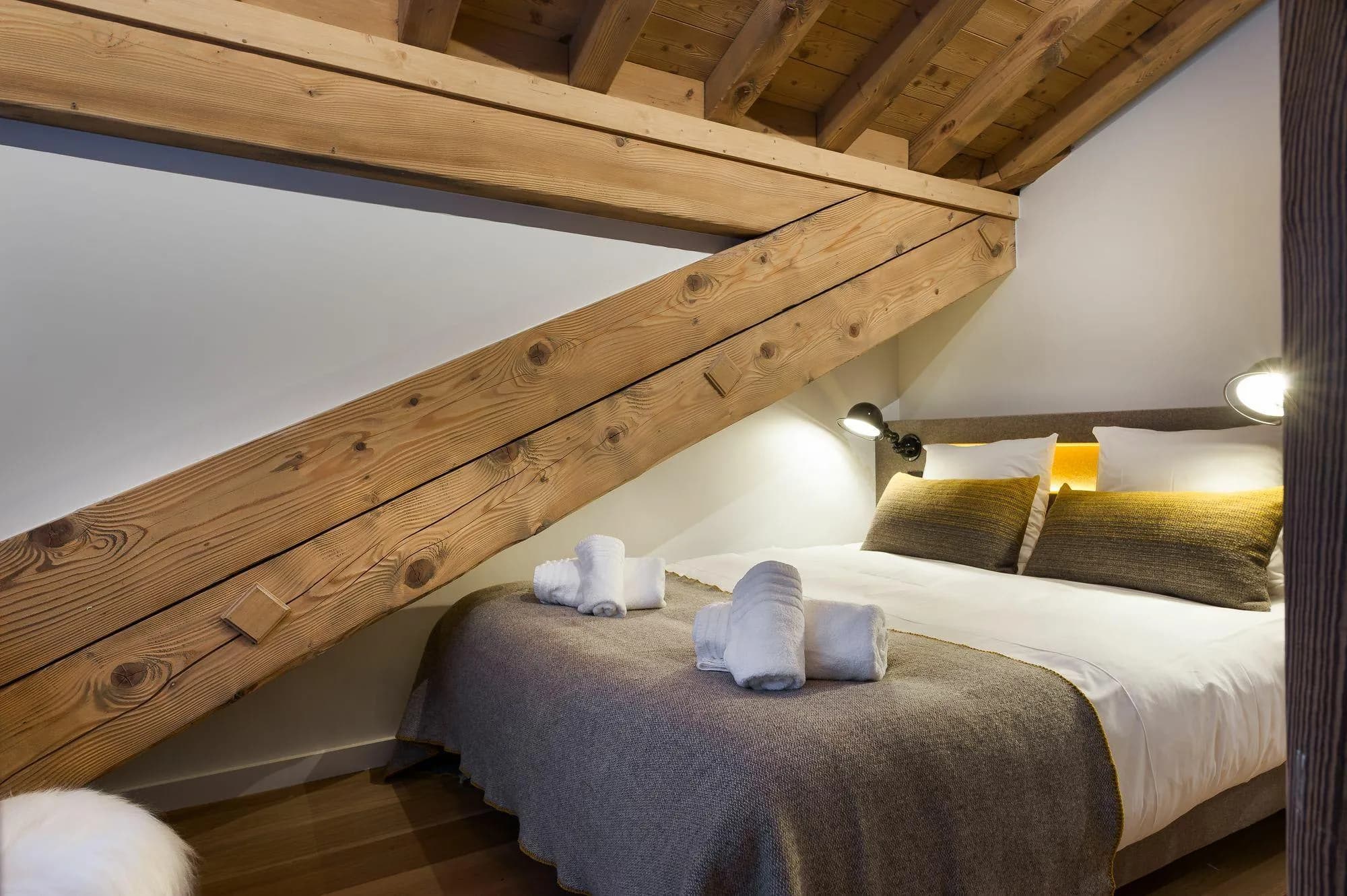Attic bedroom with queen bed, reading lights, and exposed timber beams