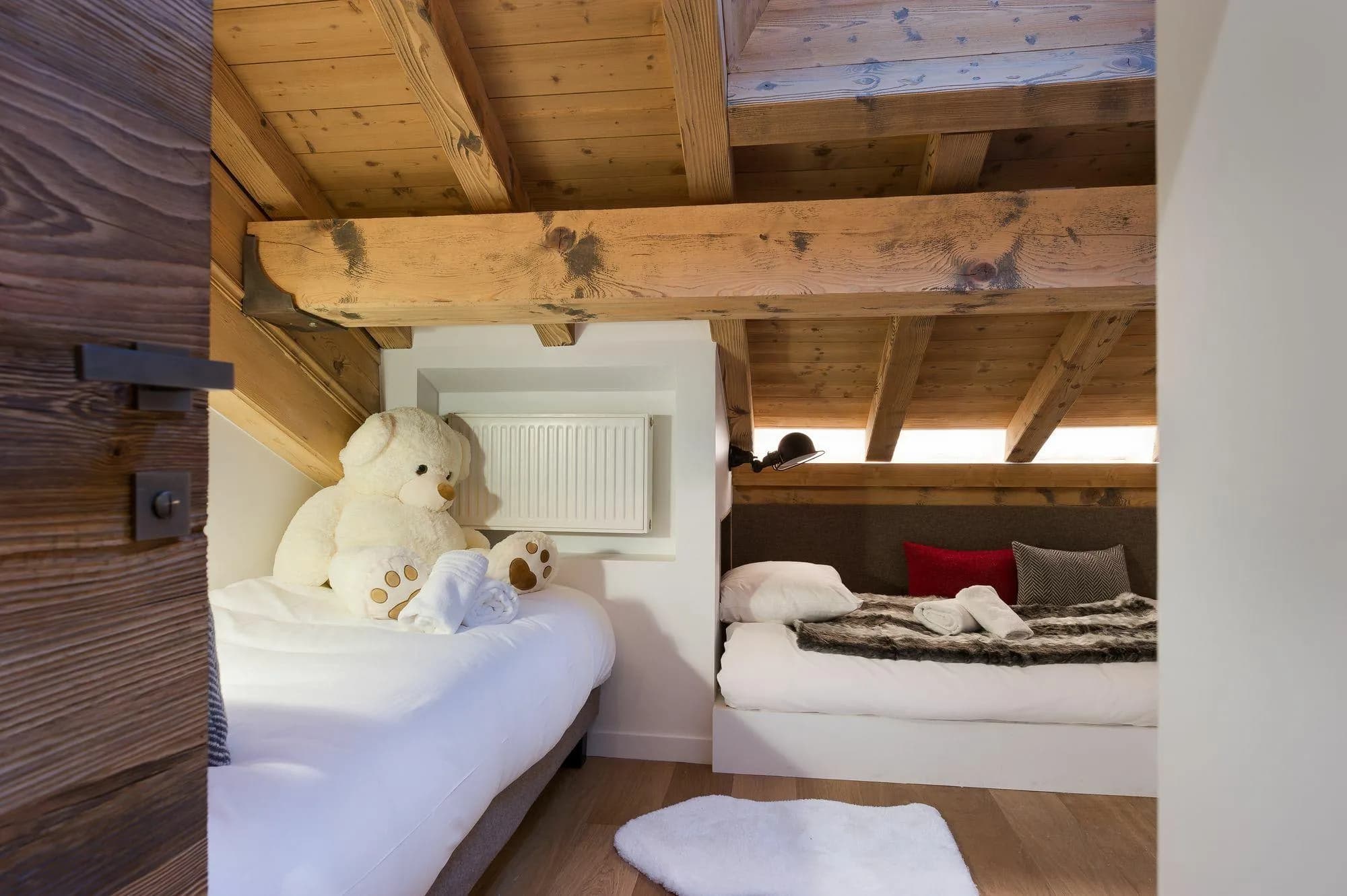 Attic twin bedroom with exposed timber beams and reading lights