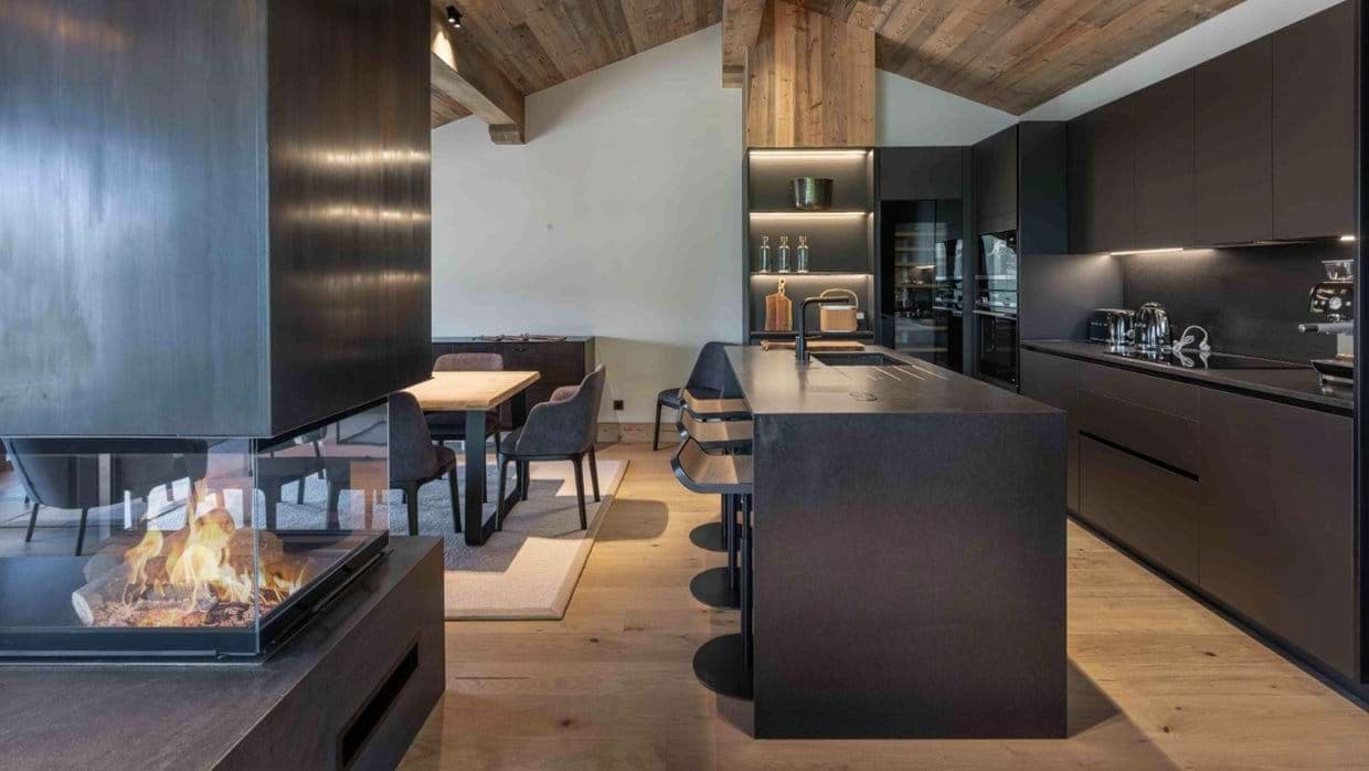 Open-plan kitchen with island seating, wine fridge, and three-sided fireplace