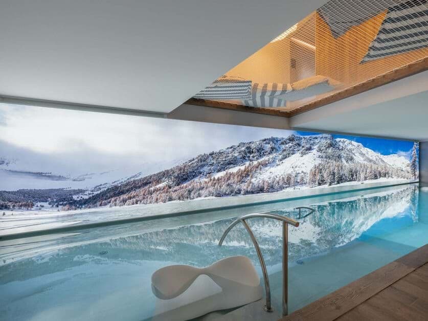 Indoor infinity pool with mountain views and overhead net loft
