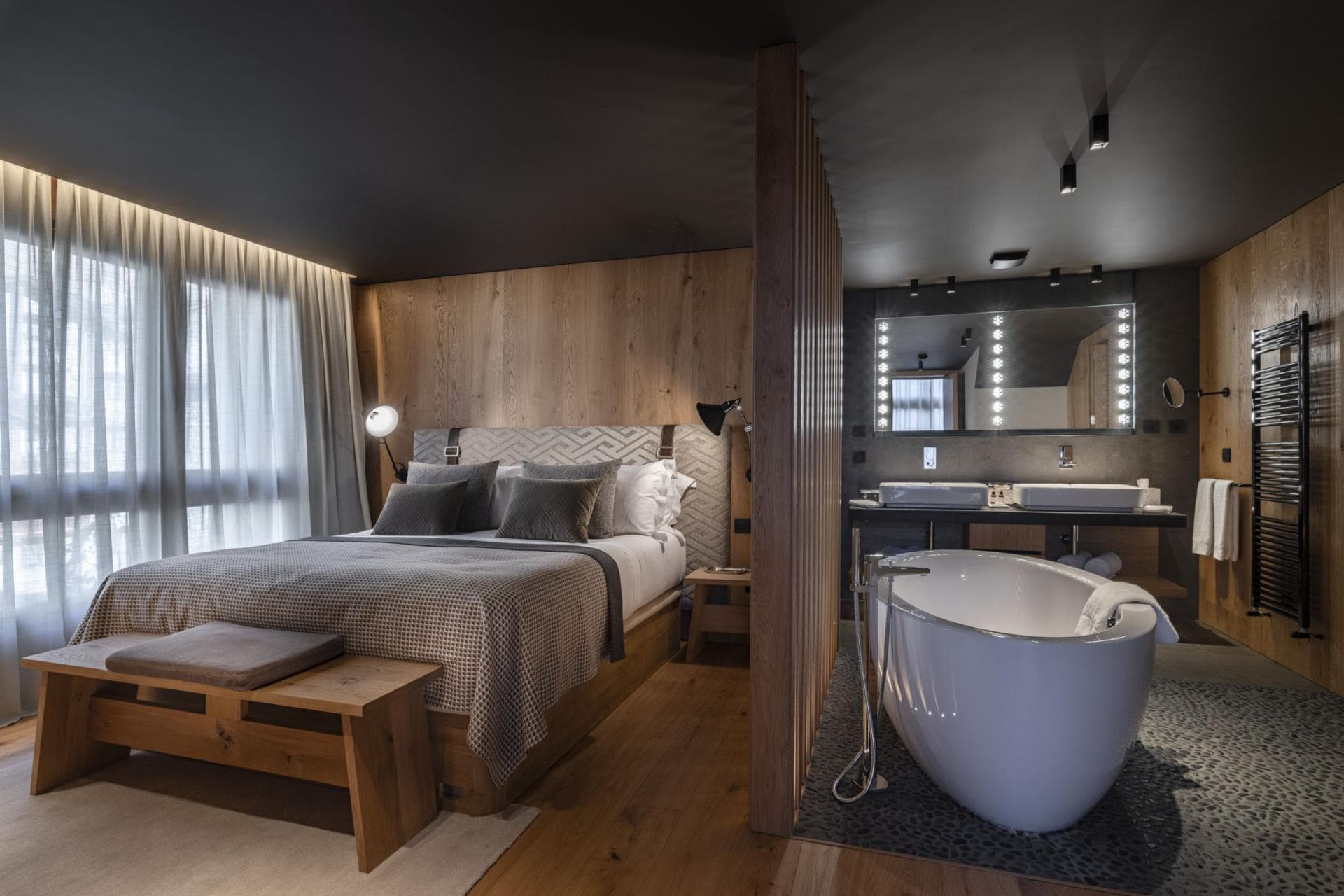 Primary suite with king bed and open-concept bath featuring soaking tub