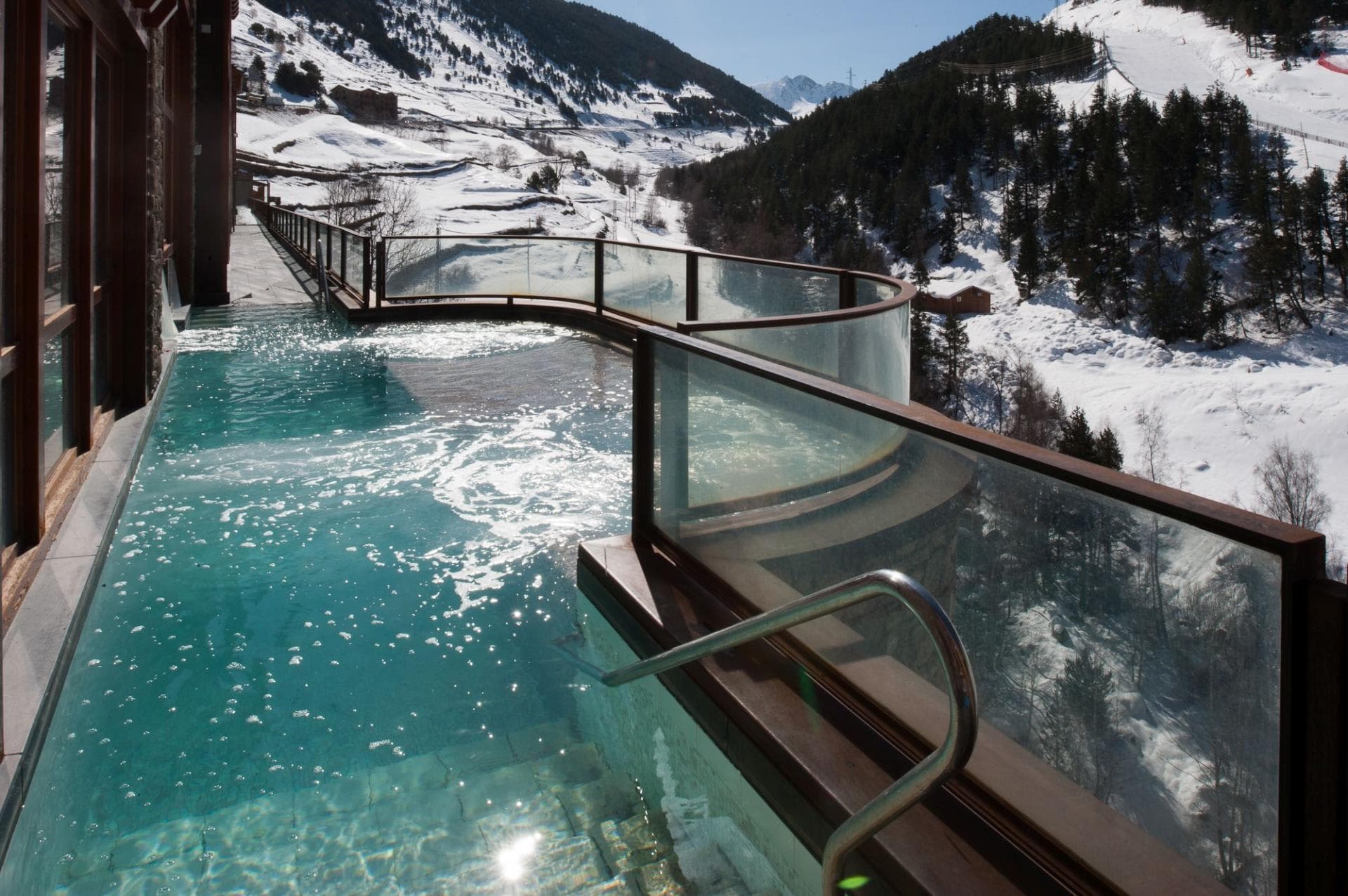Heated infinity pool and hot tub with ski slope views