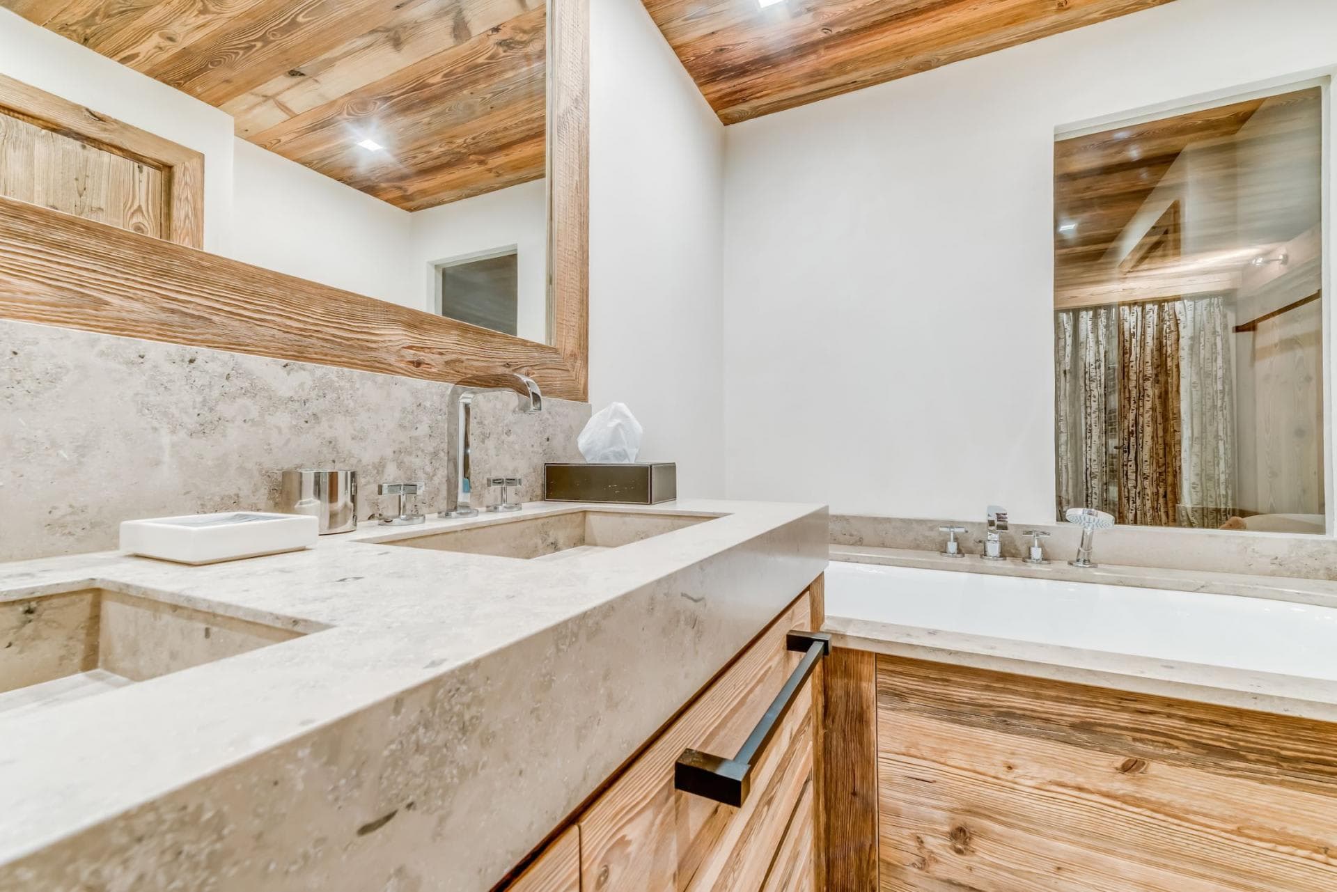 Bathroom with dual stone vanities and soaking tub