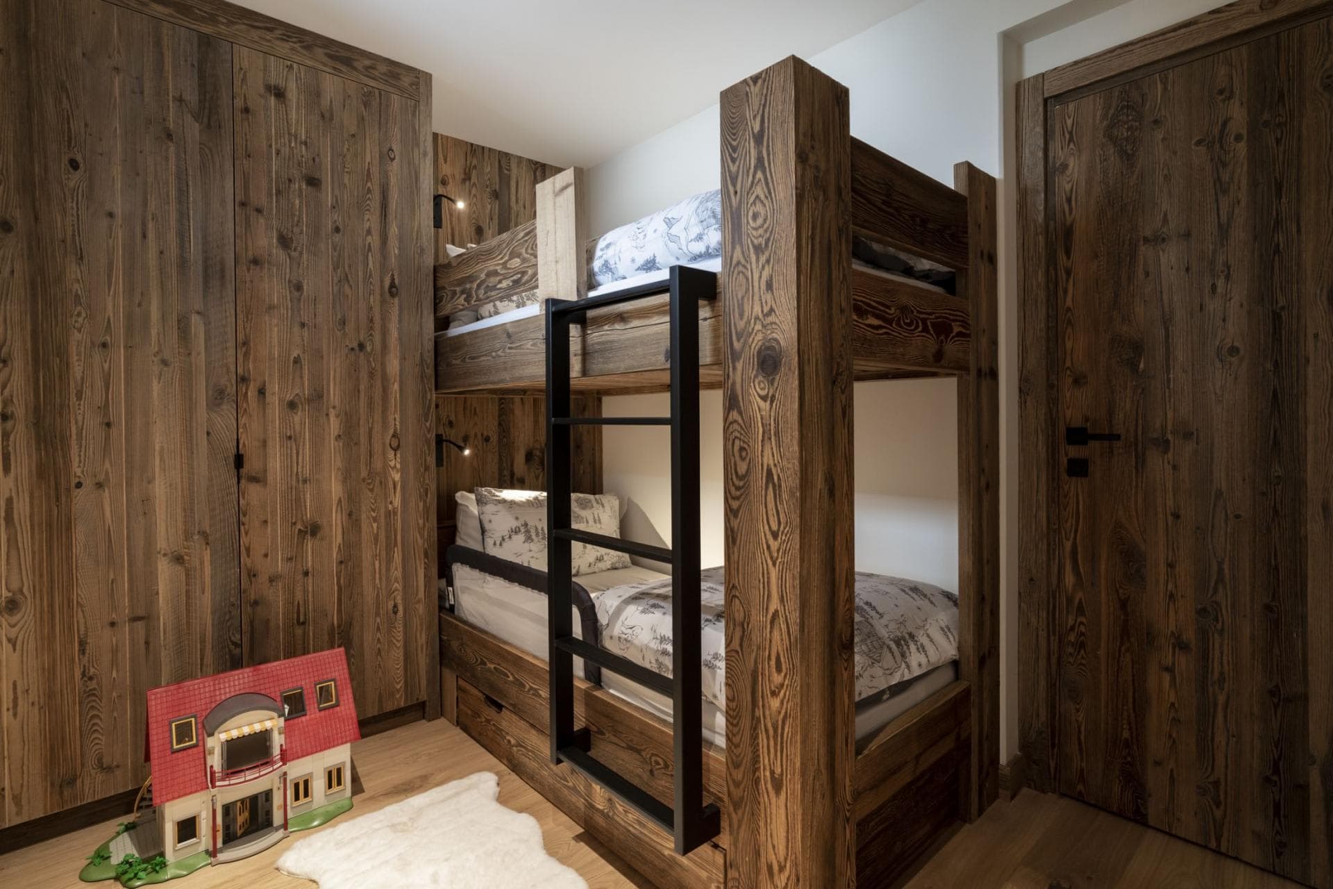 Bunk room with two twin beds and integrated wood wardrobe
