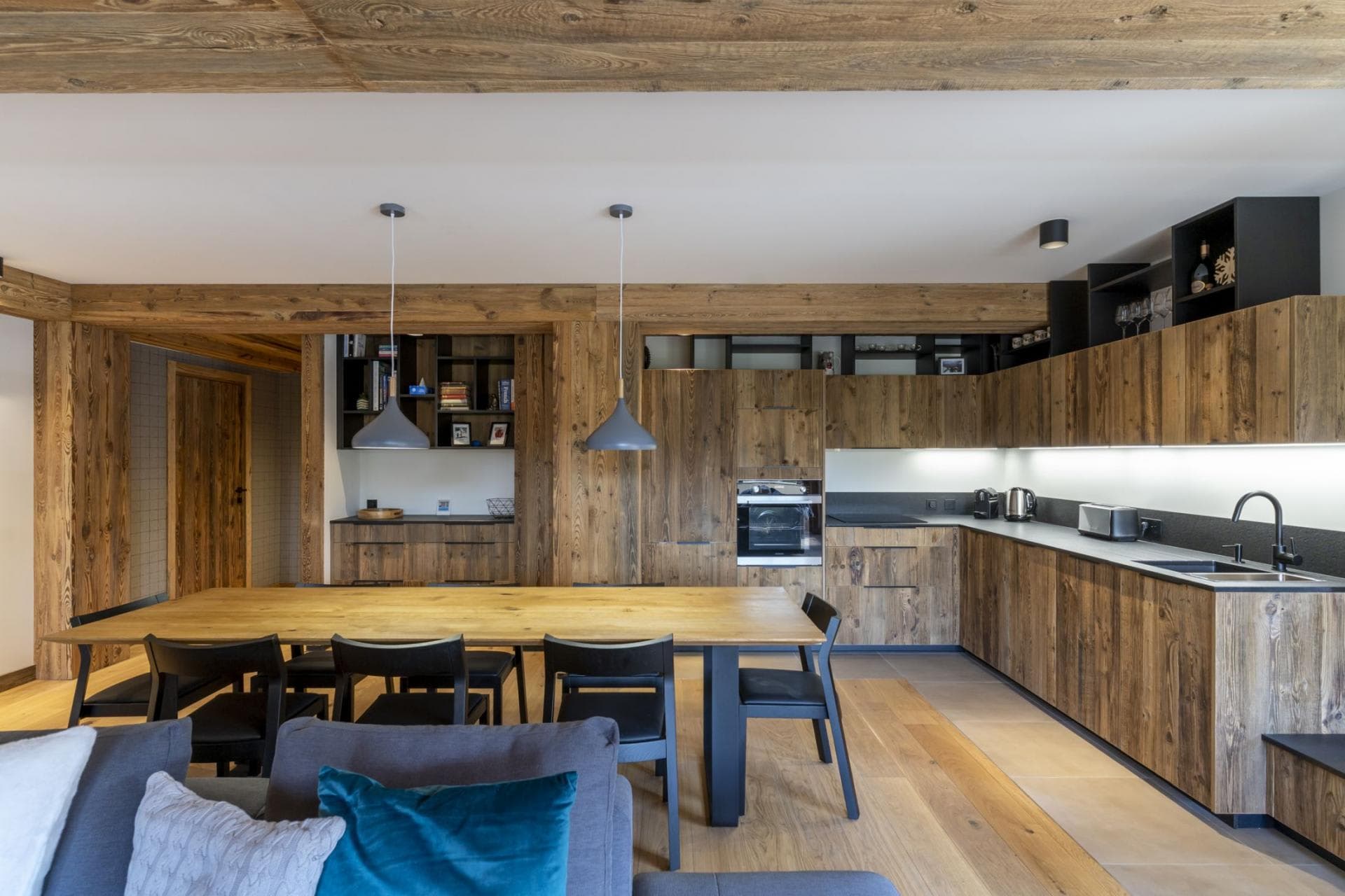 Open-concept kitchen and dining area with reclaimed wood cabinetry and seating for 8