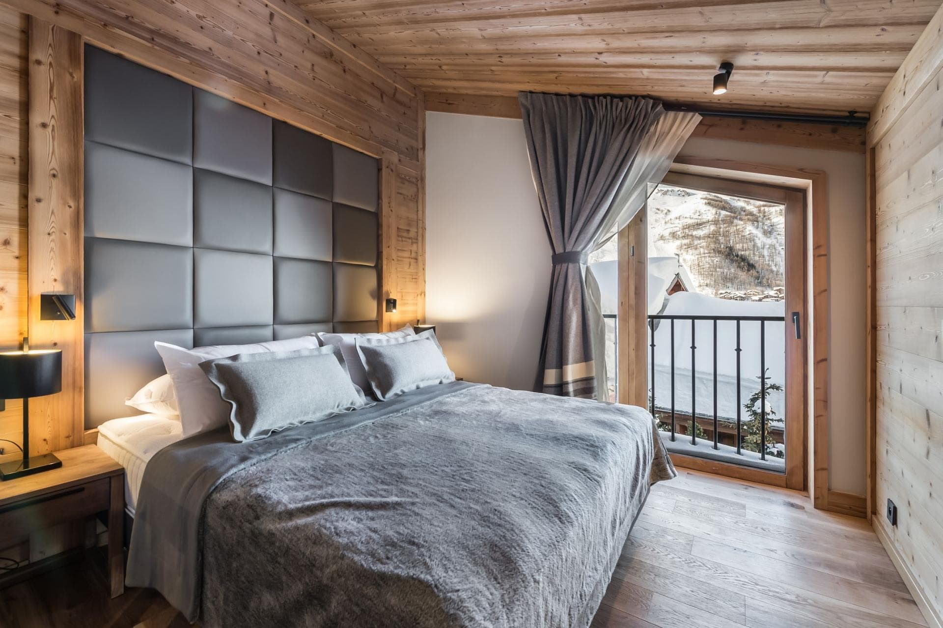 Bedroom with king bed and private balcony overlooking snow-covered mountains