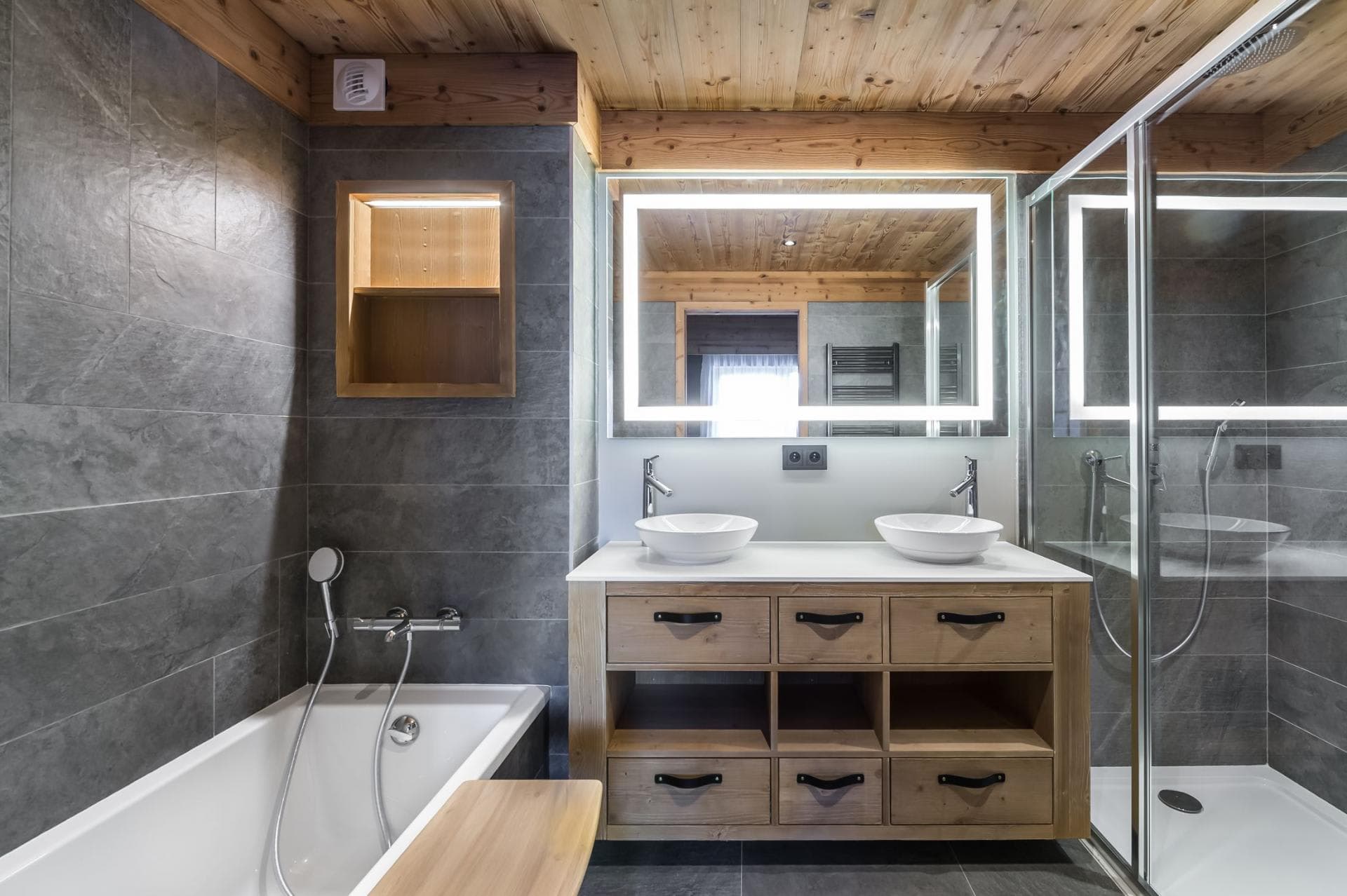 Bathroom with dual vessel sinks, walk-in shower, and soaking tub