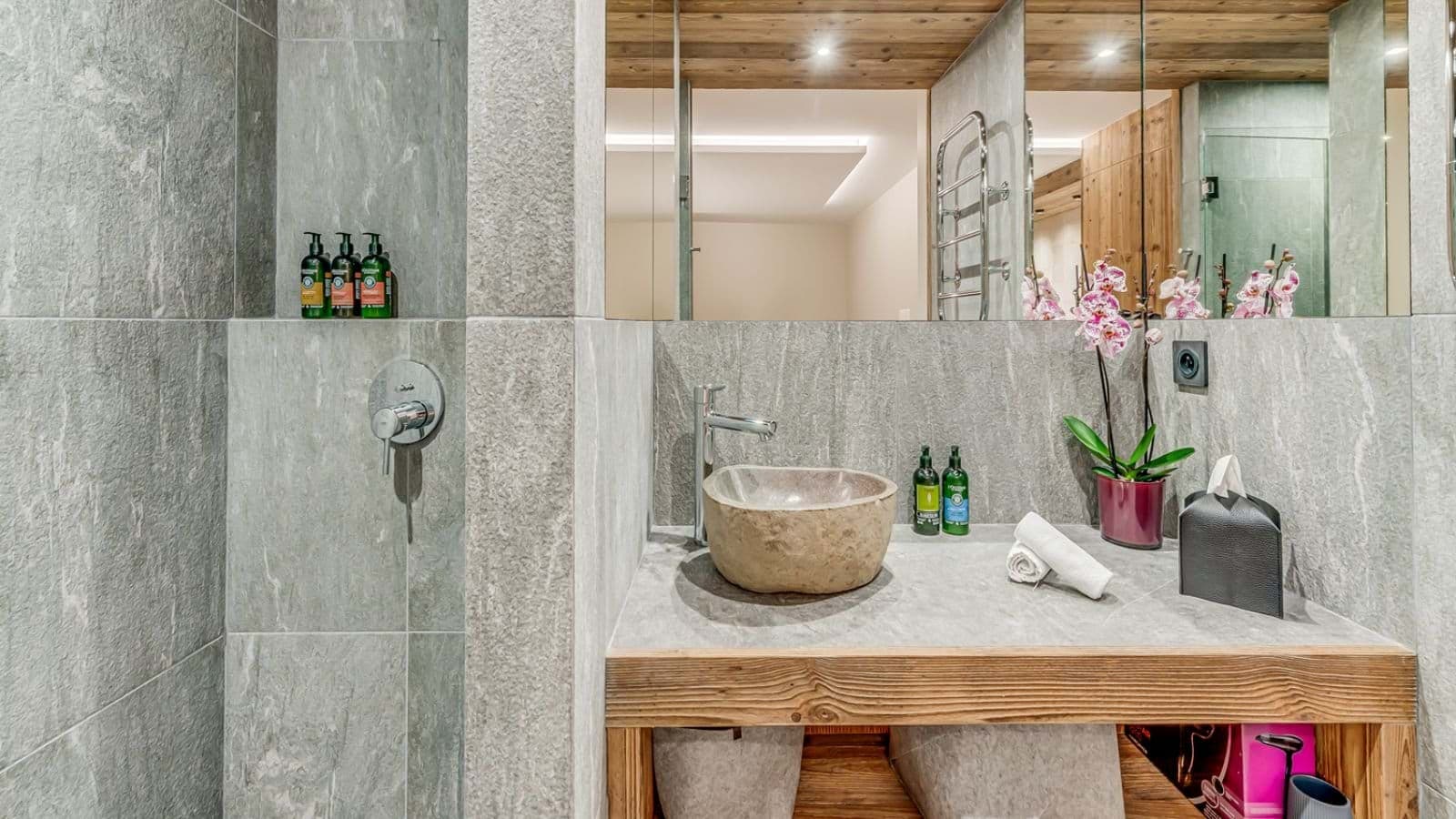 Bathroom featuring stone vessel sink and heated towel rack