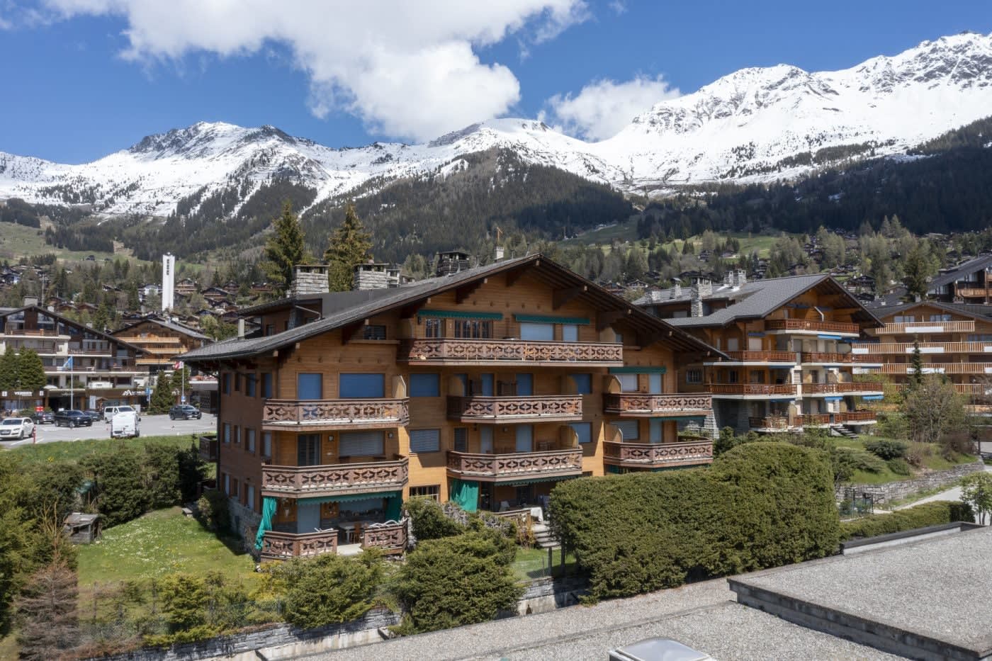 Wooden chalet building with private balconies and views of snow-capped mountains