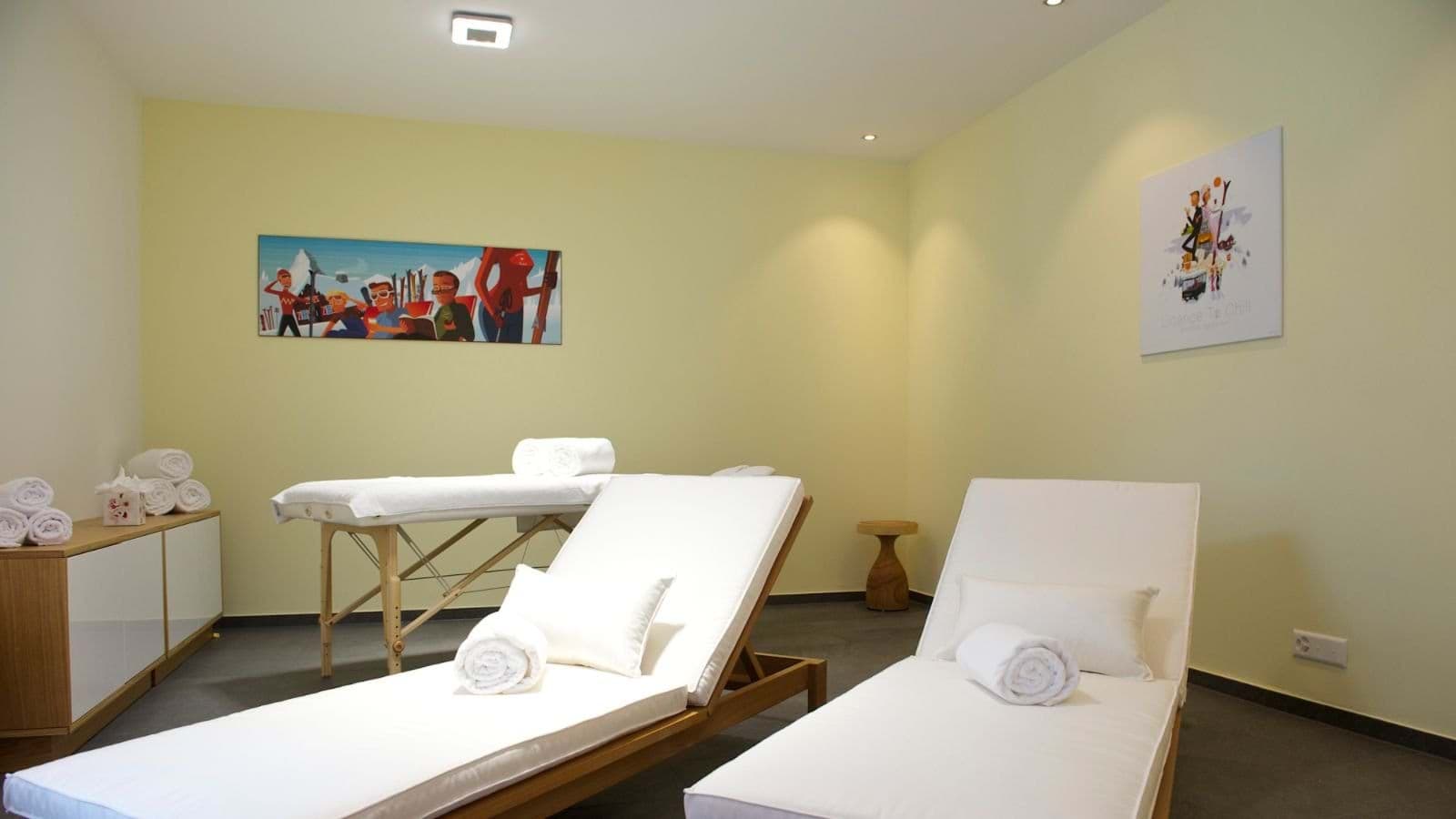 Private spa room with massage table and two lounge chairs