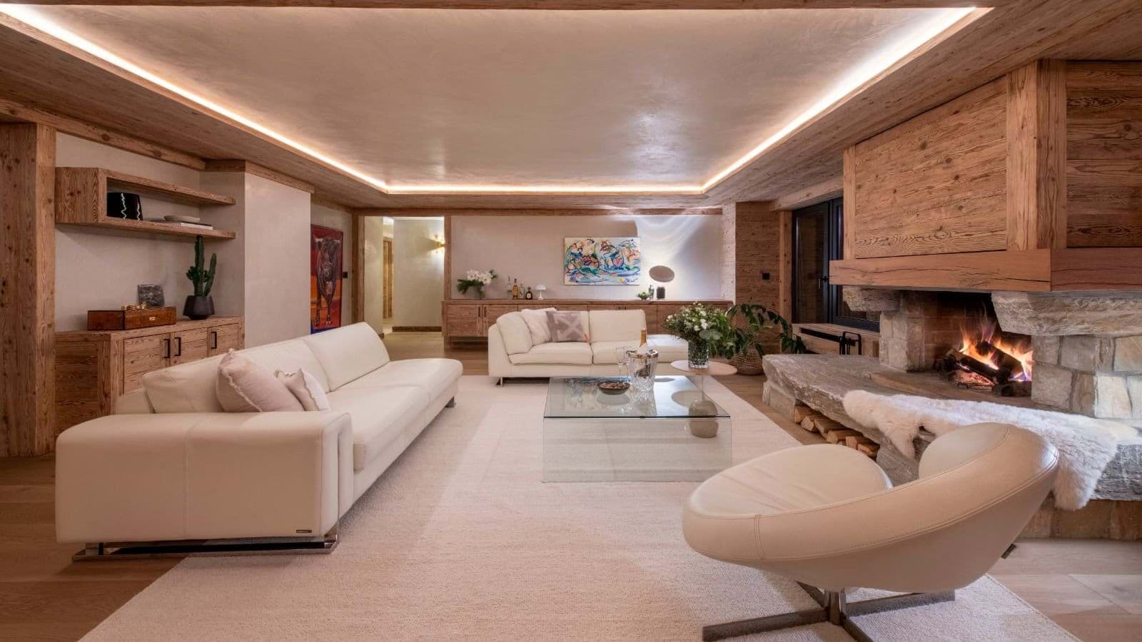 Living area with wood-burning fireplace and recessed cove lighting