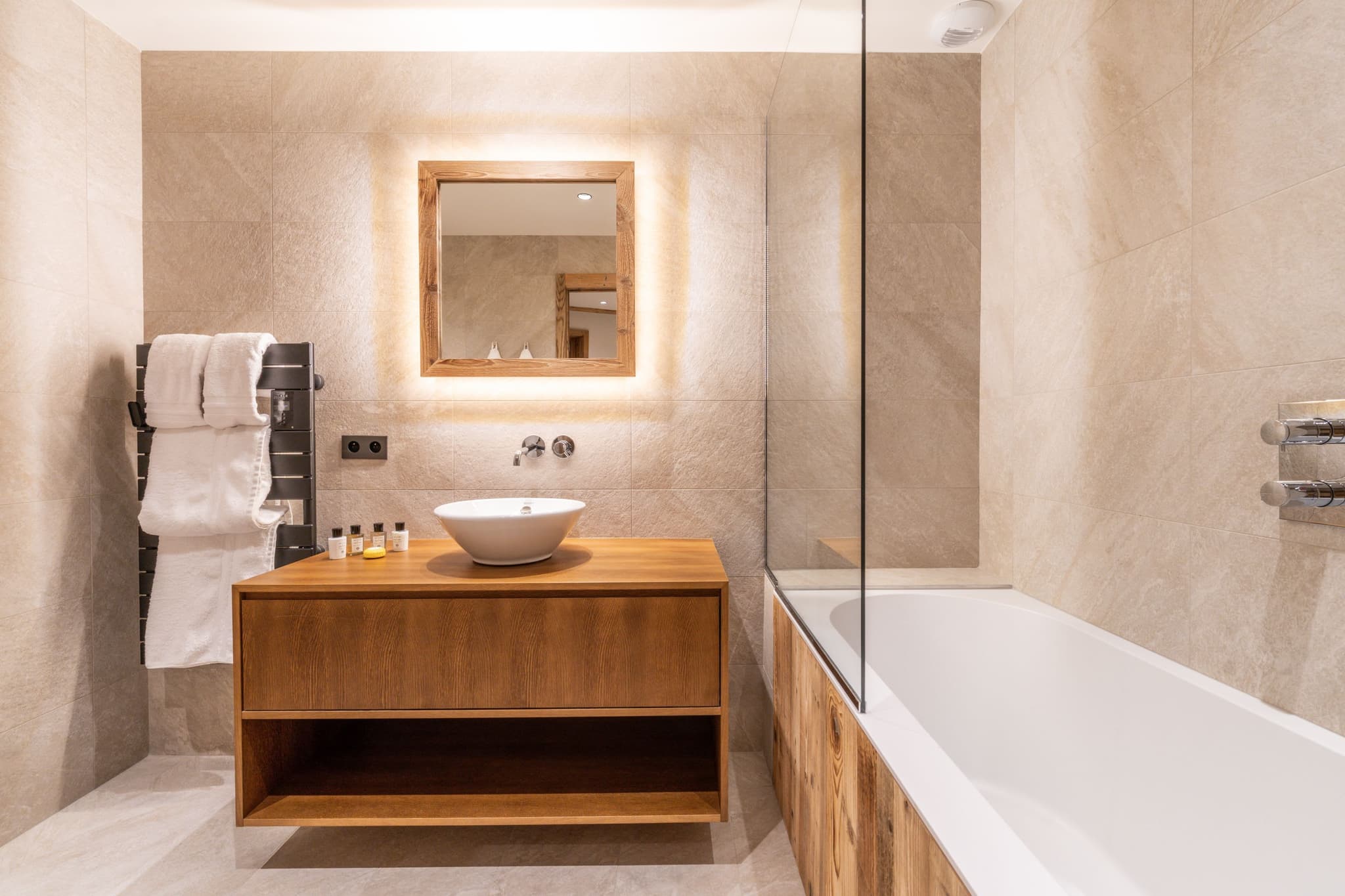 Bathroom with soaking tub, vessel sink, and heated towel rack