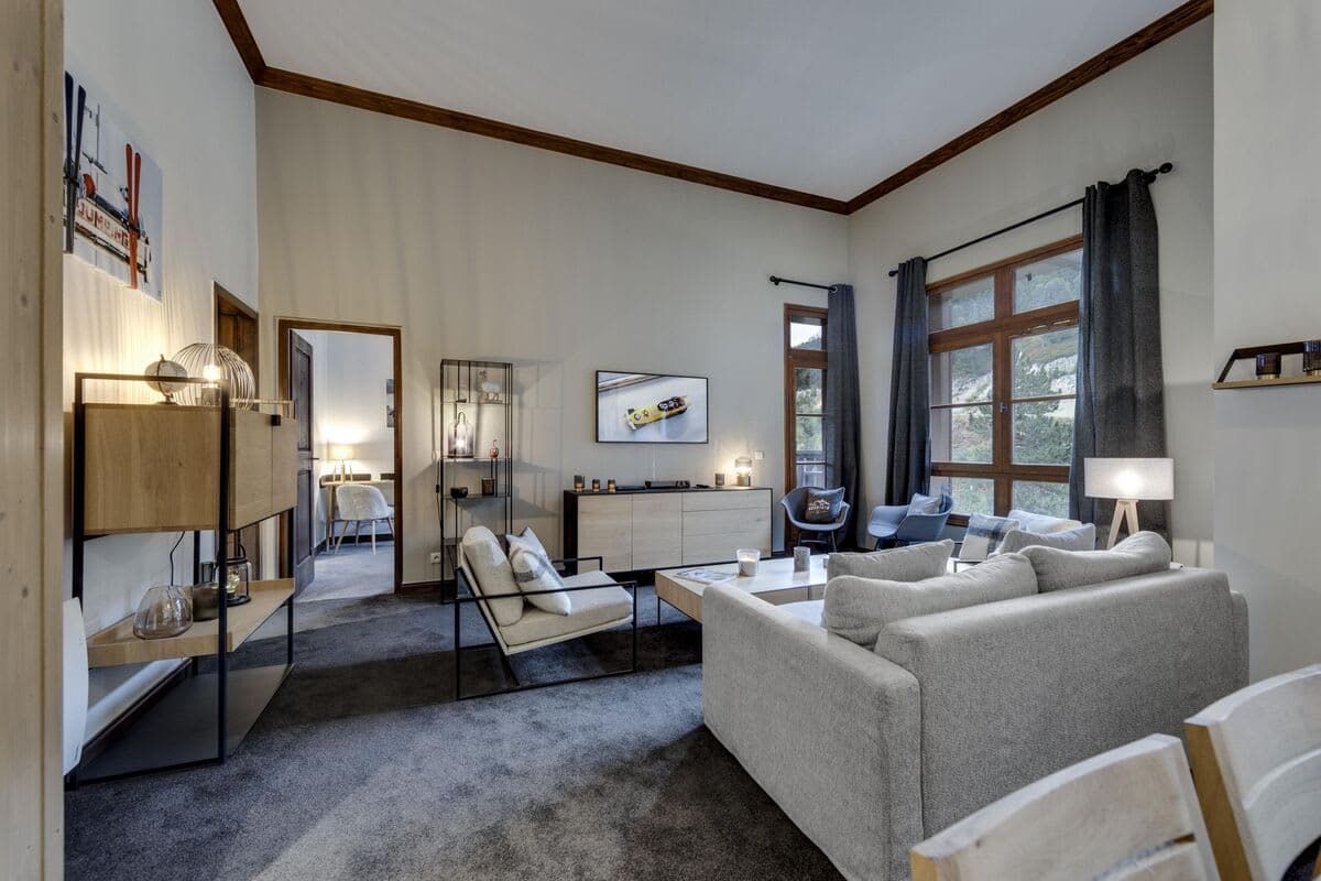 Living room with high ceilings and large windows overlooking mountains