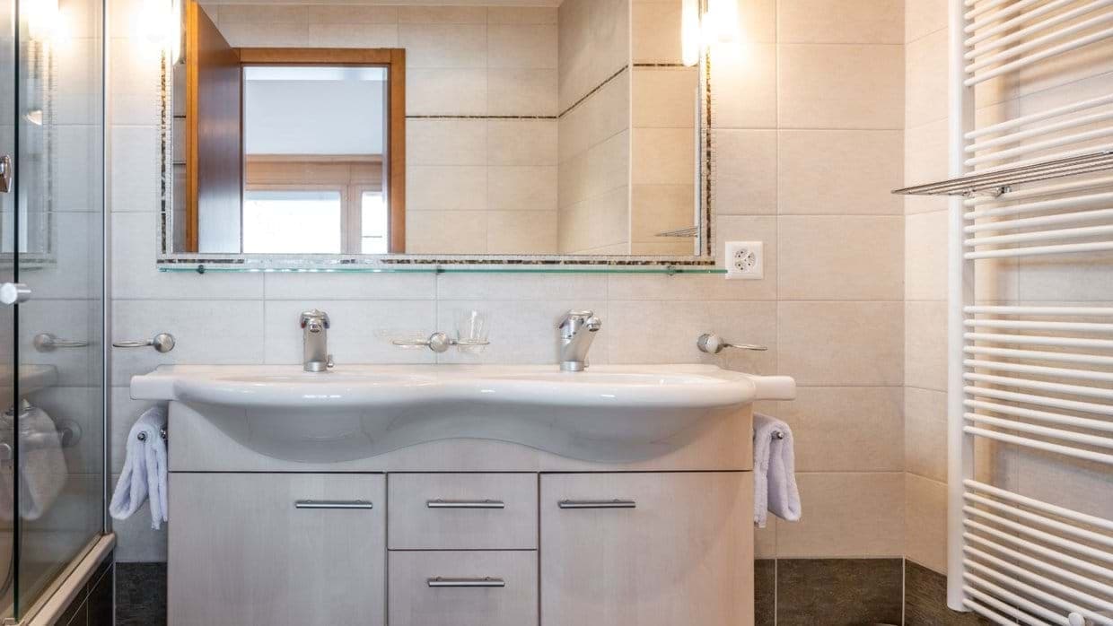 Bathroom with double vanity and heated towel rack