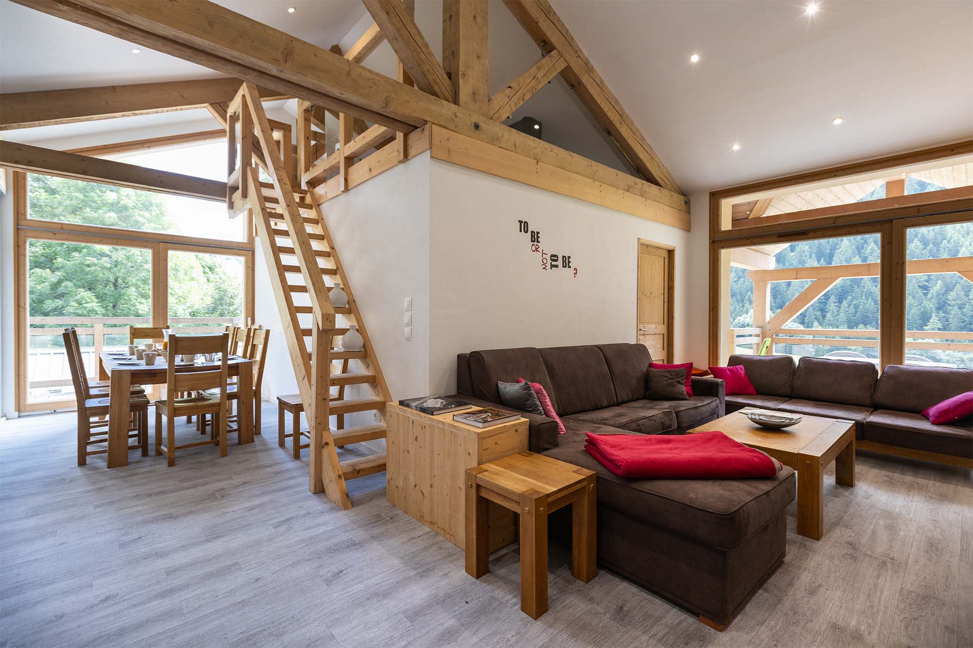 Open living area with vaulted timber beams and loft access