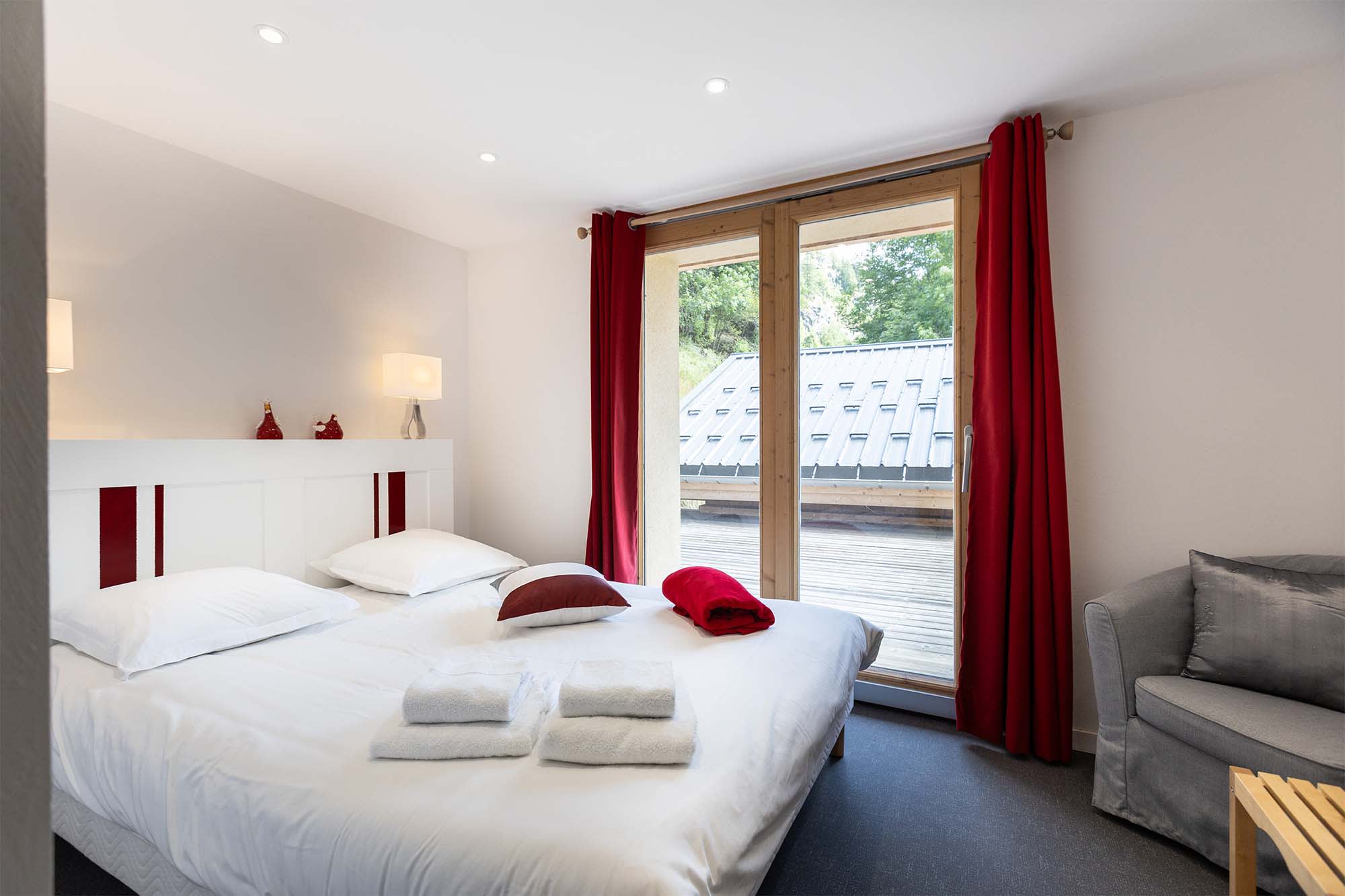 Guest bedroom with double bed and sliding door access to private deck