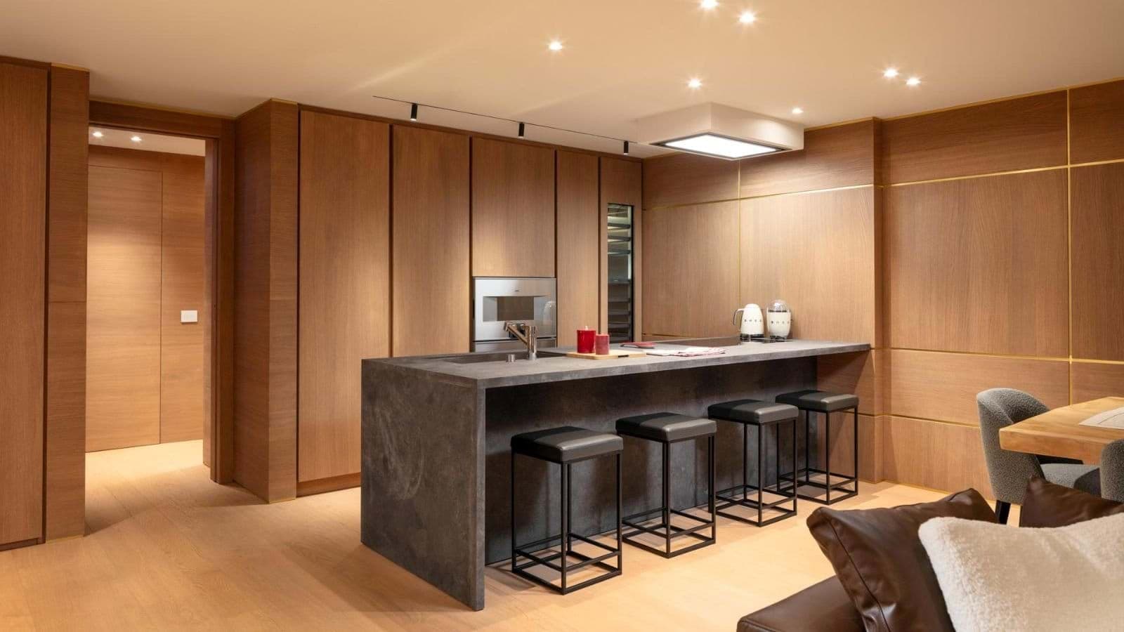 Kitchen island with stone countertop, bar seating for 4, and wine fridge