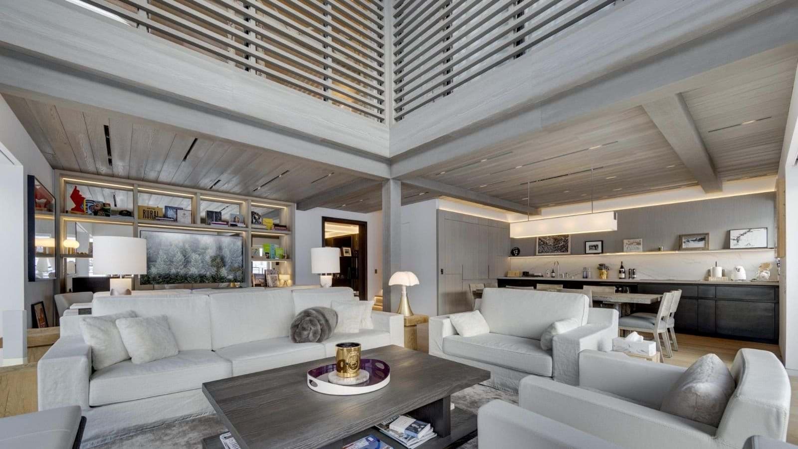 Open living area with double-height ceiling and adjacent kitchenette