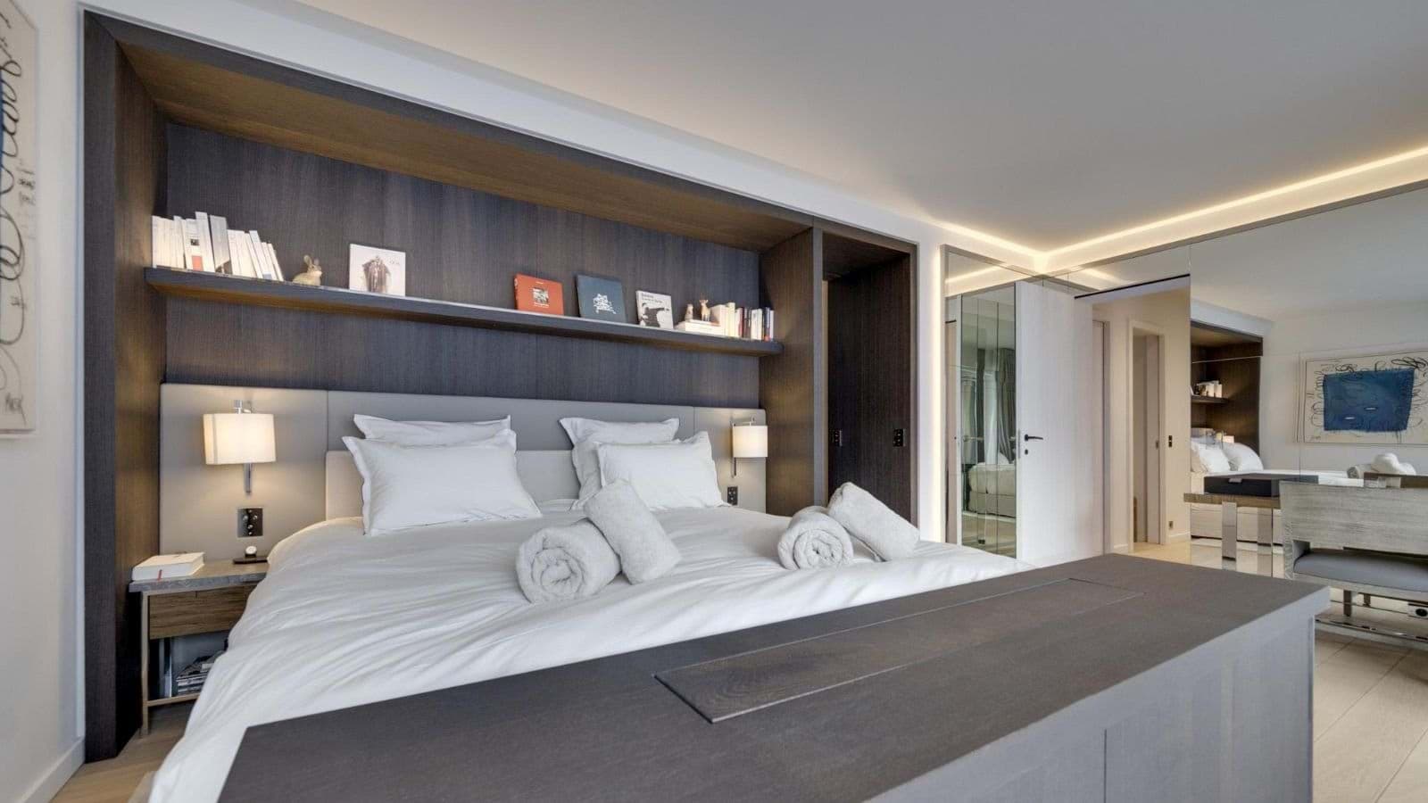 Primary bedroom with king bed, integrated shelving, and hidden desk area