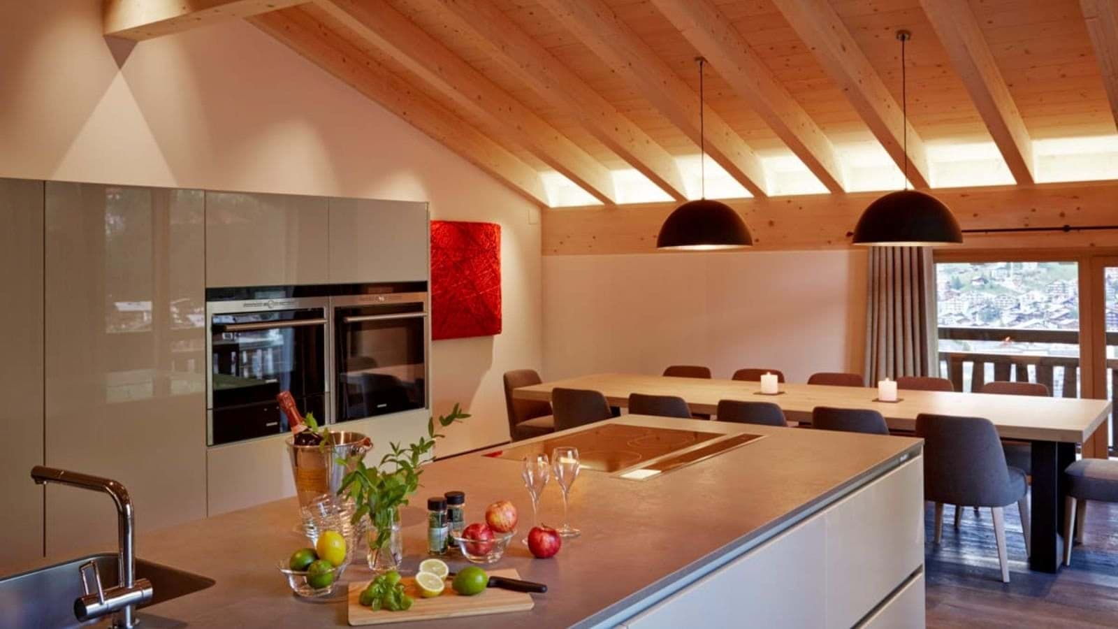 Open-plan kitchen and dining area with dual ovens; table seats 10