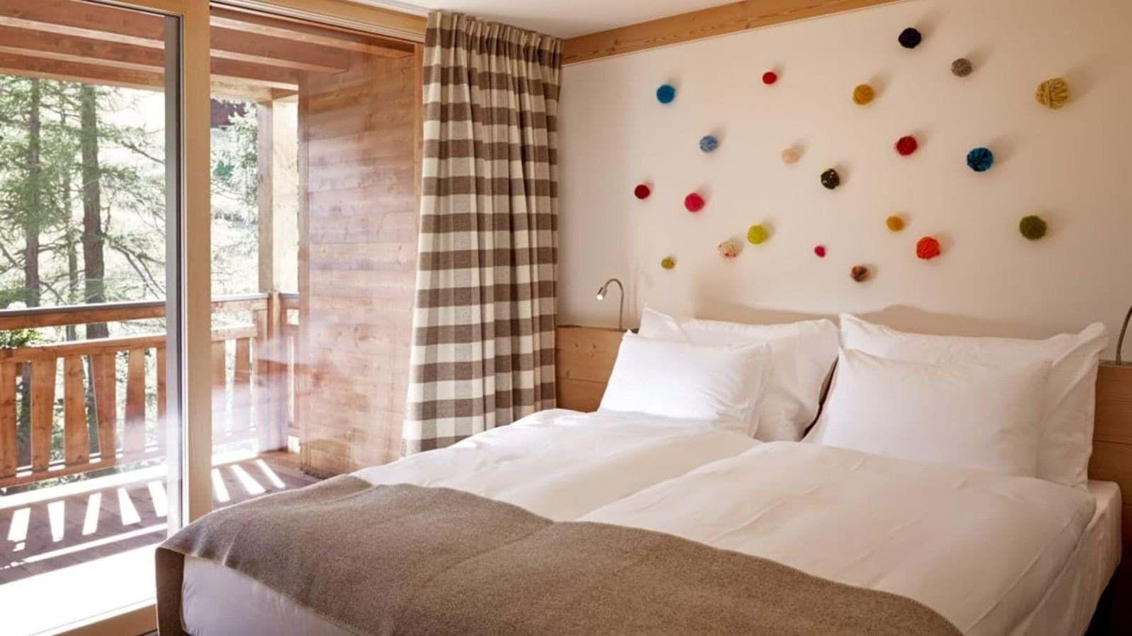 Guest bedroom with balcony access and forest views